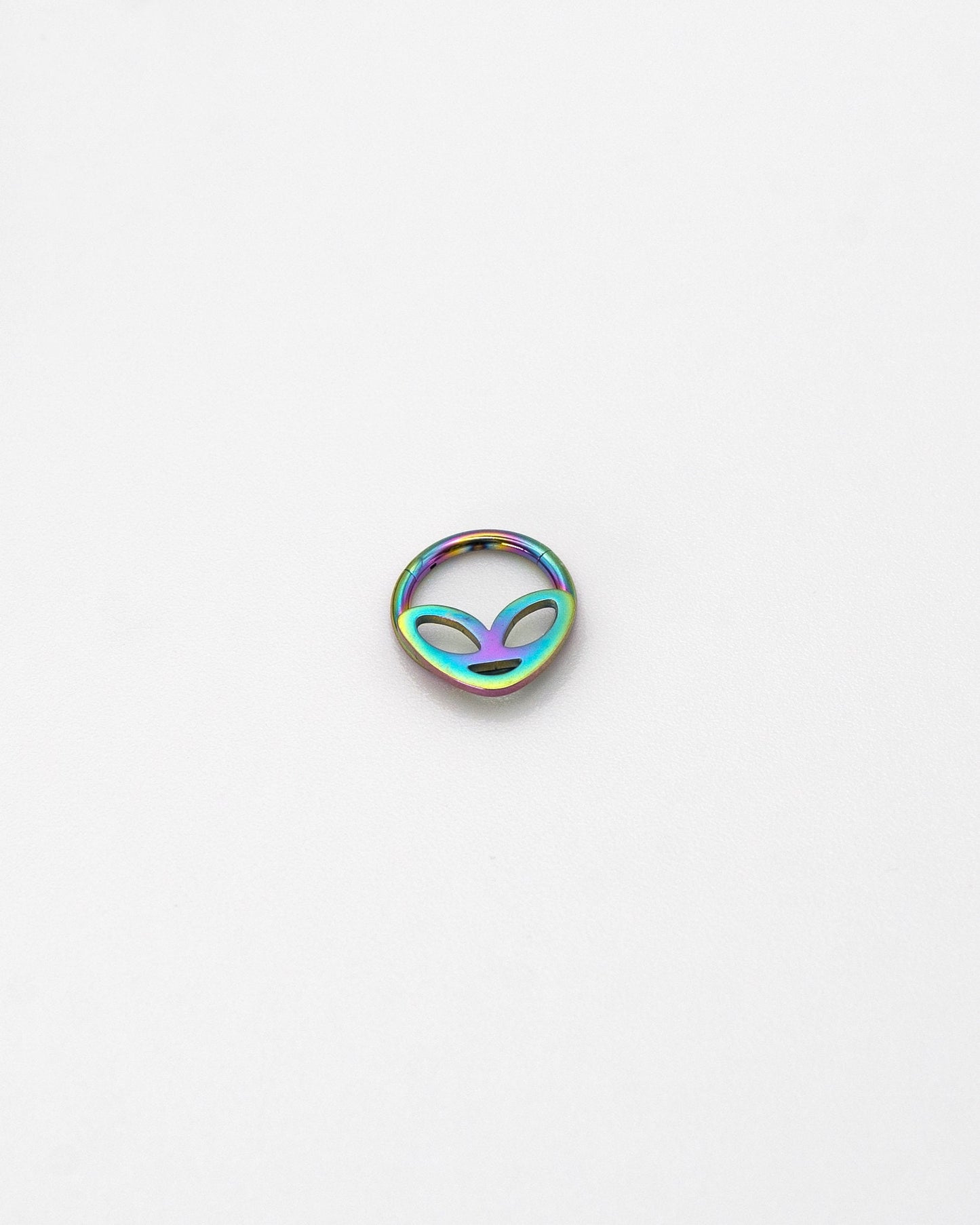 Alien-themed septum clicker in rainbow finish, displayed on a white background.