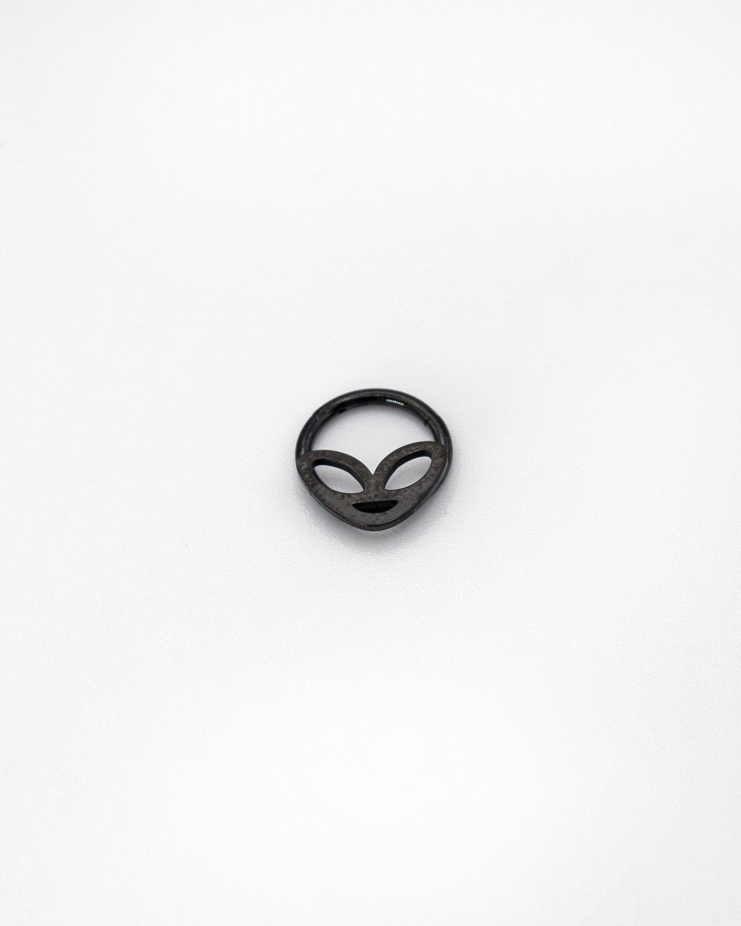 Alien-themed septum clicker in black finish, displayed on a white background.