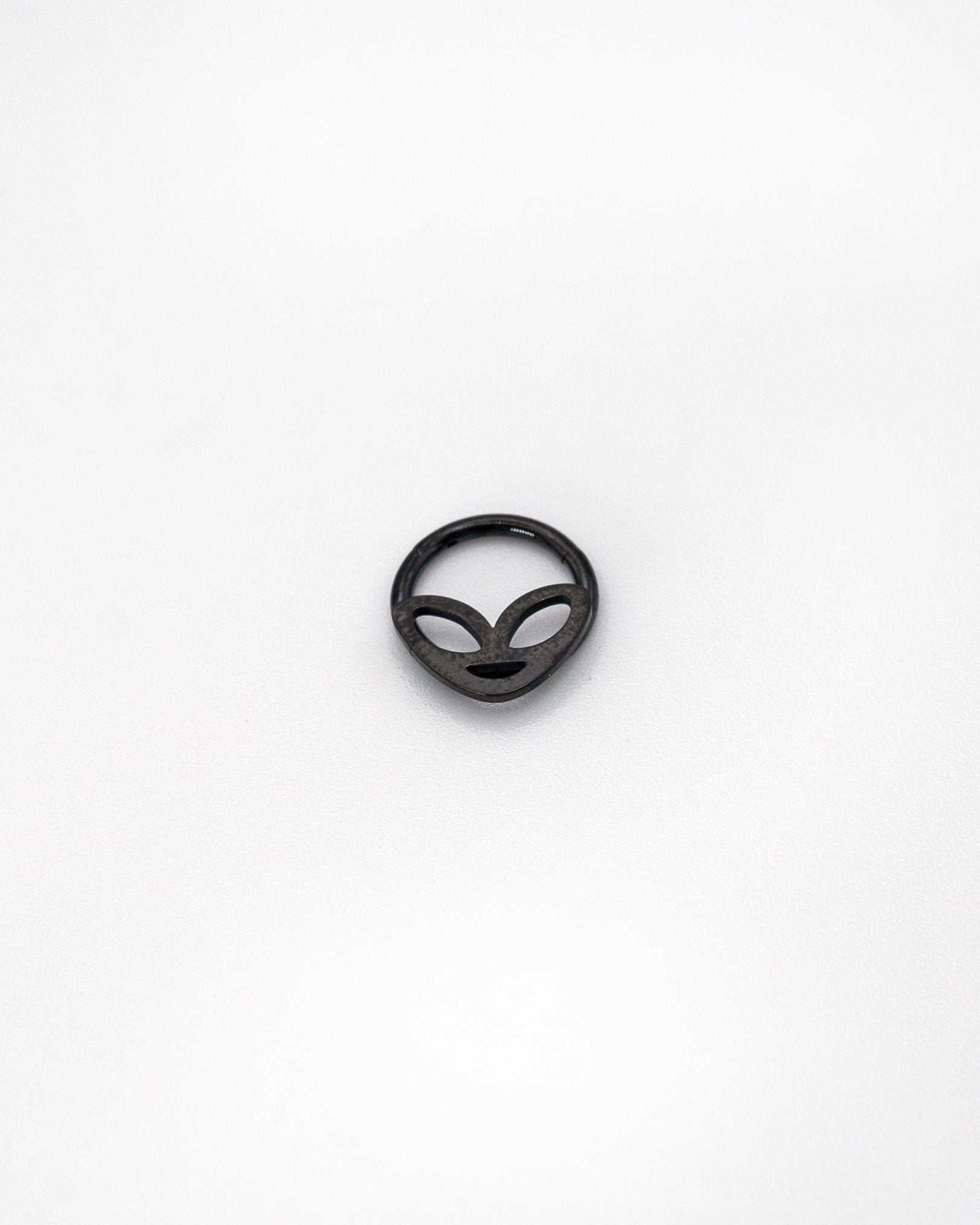 Alien-themed septum clicker in black finish, displayed on a white background.