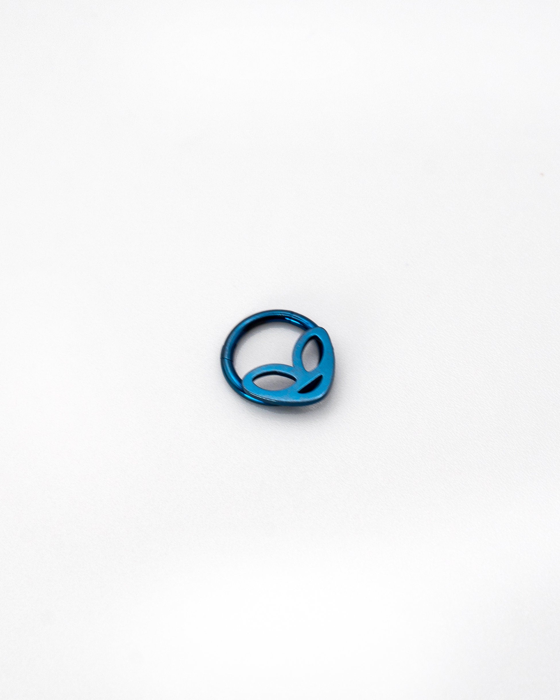 Alien-themed septum clicker in blue finish, displayed on a white background.