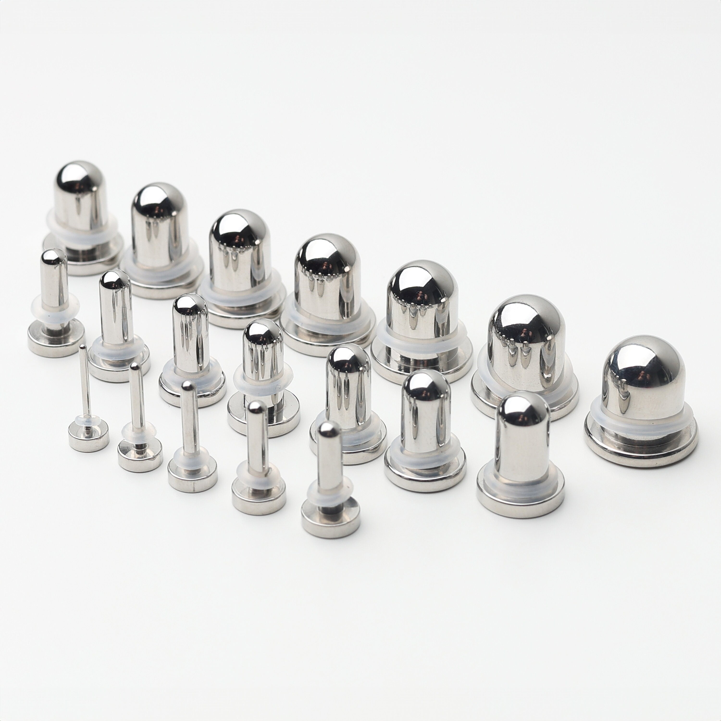 A complete dead stretching kit with polished stainless steel plugs and tunnels in multiple sizes, displayed on a white background.