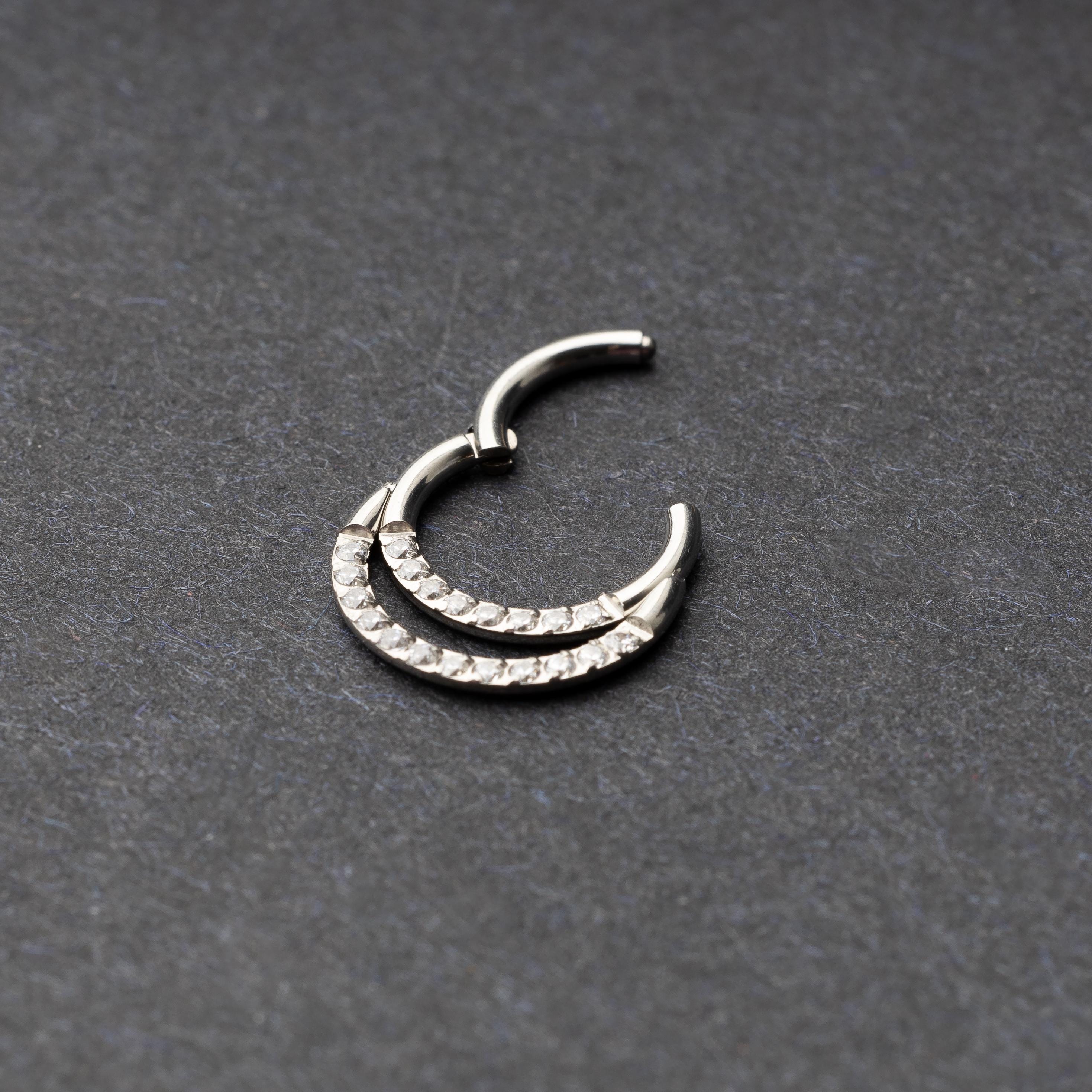 Titanium double-layered clicker with sparkling cubic zirconia accents, displayed on a dark background.