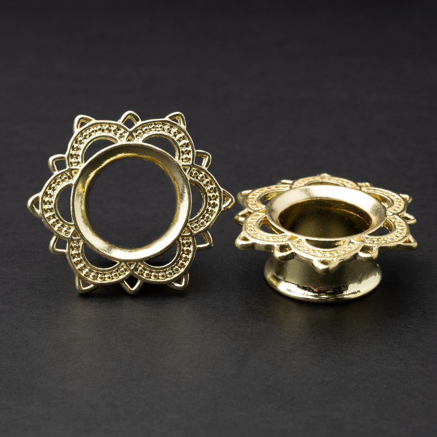 Gold flower-shaped tunnels with intricate detailing, displayed on a dark background.