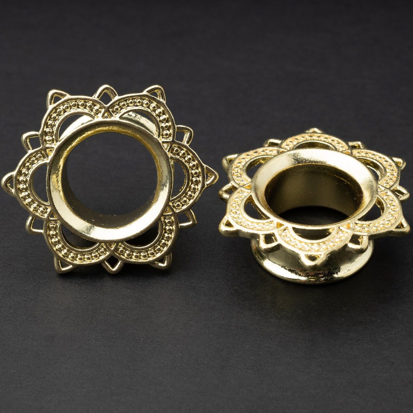 Gold flower-shaped tunnels with intricate detailing, displayed on a dark background.
