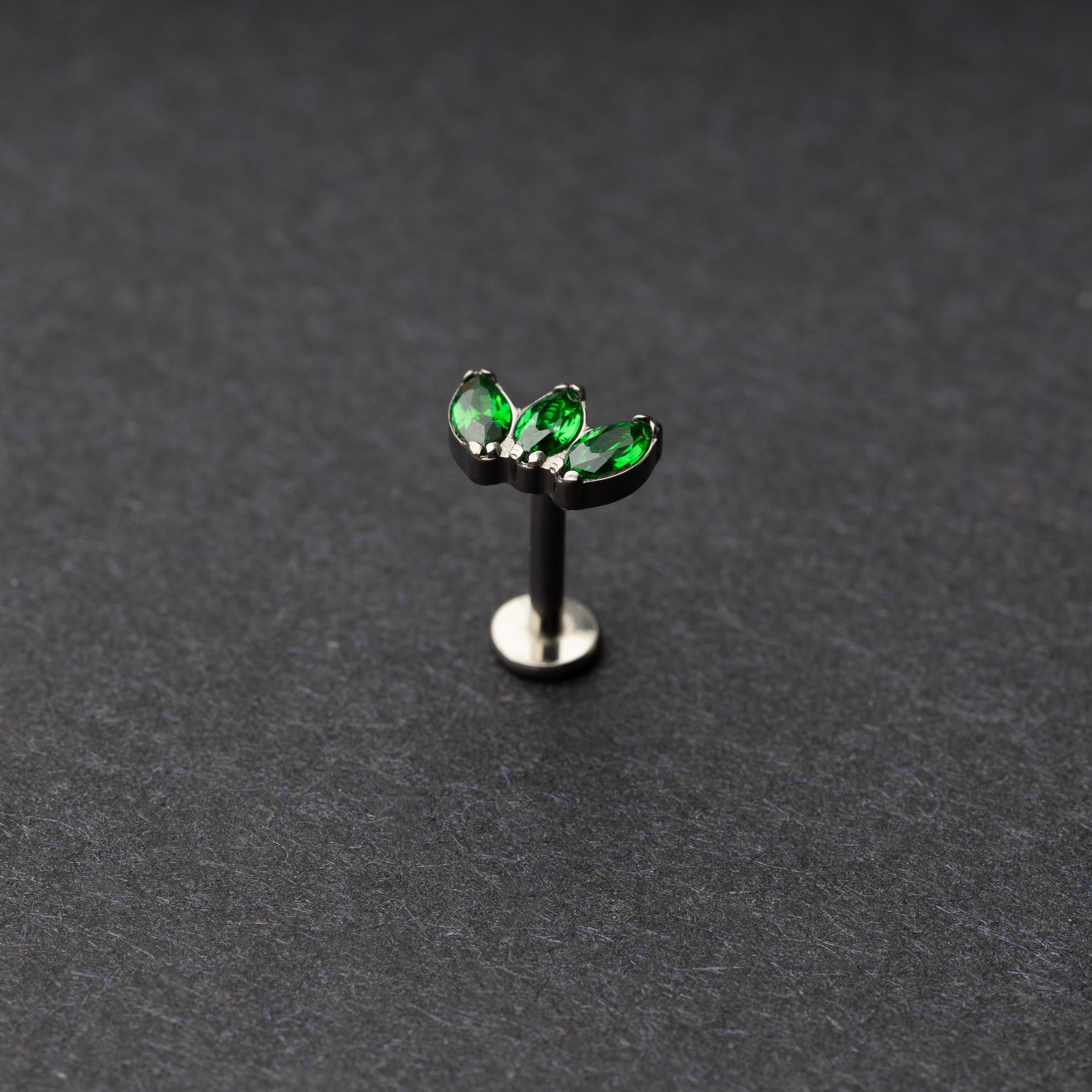 flat back bar featuring a triple gem design with emerald green gems on a silver base. displayed on a dark background.