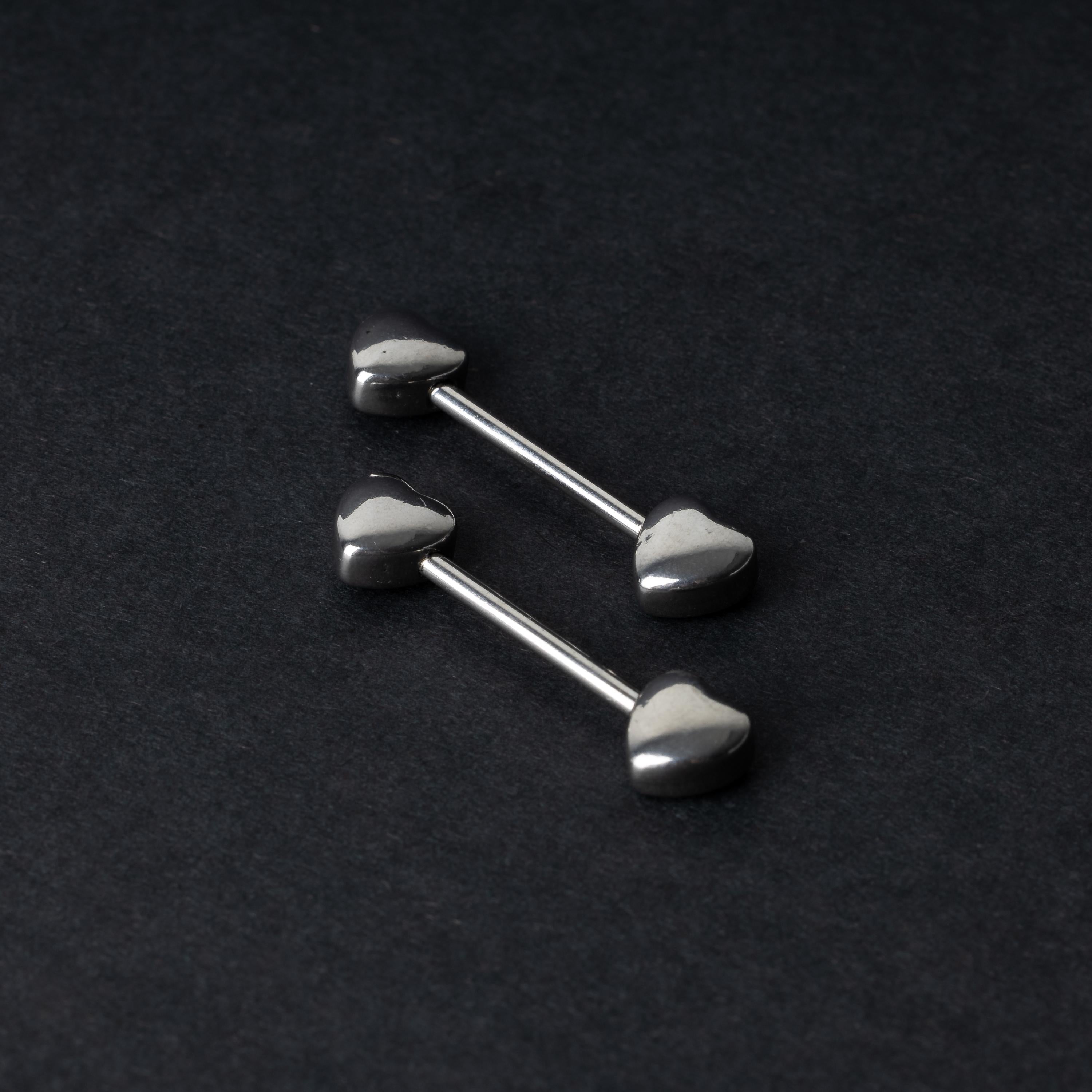 Heart-shaped silver barbells on a dark background.