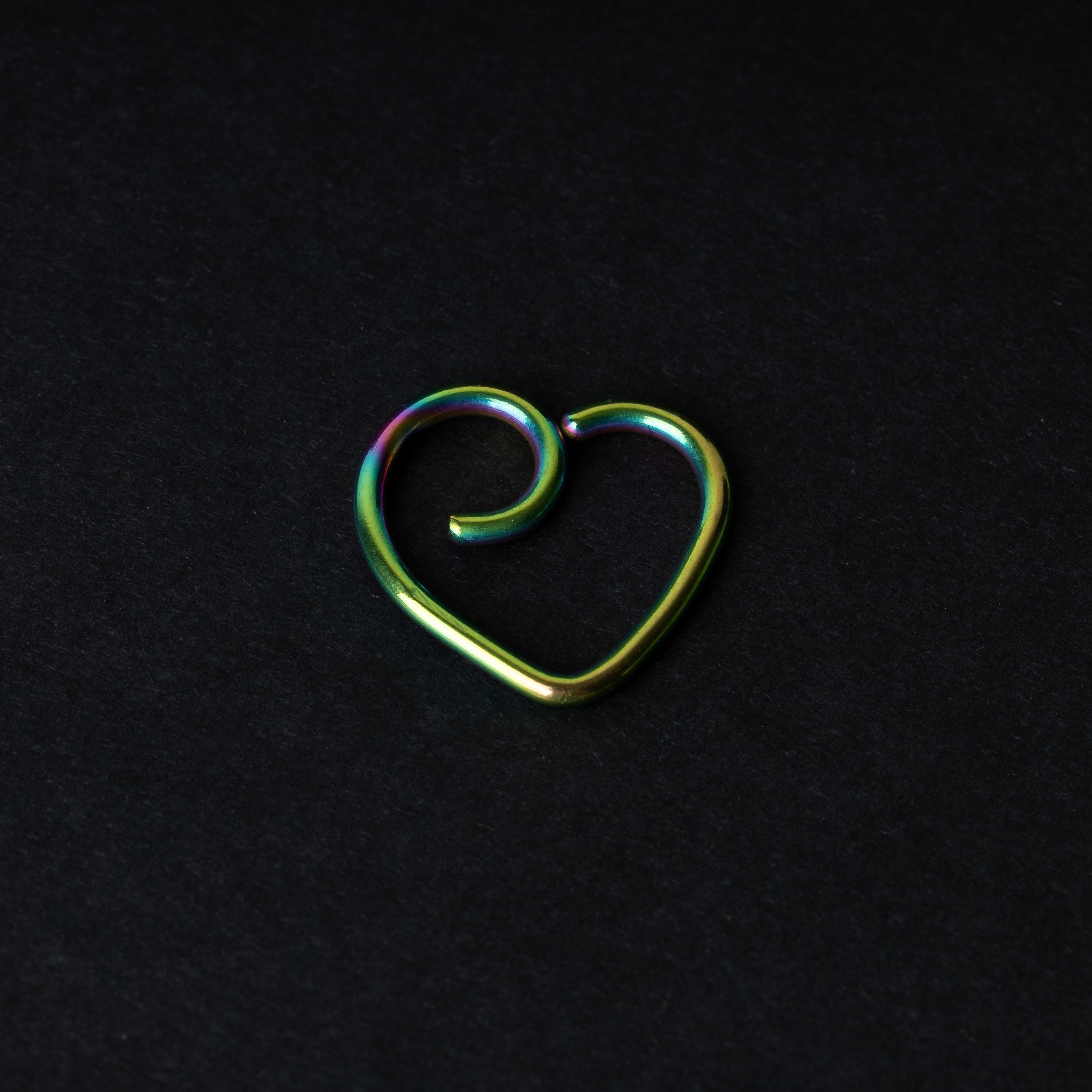 Rainbow heart shaped daith on a dark background