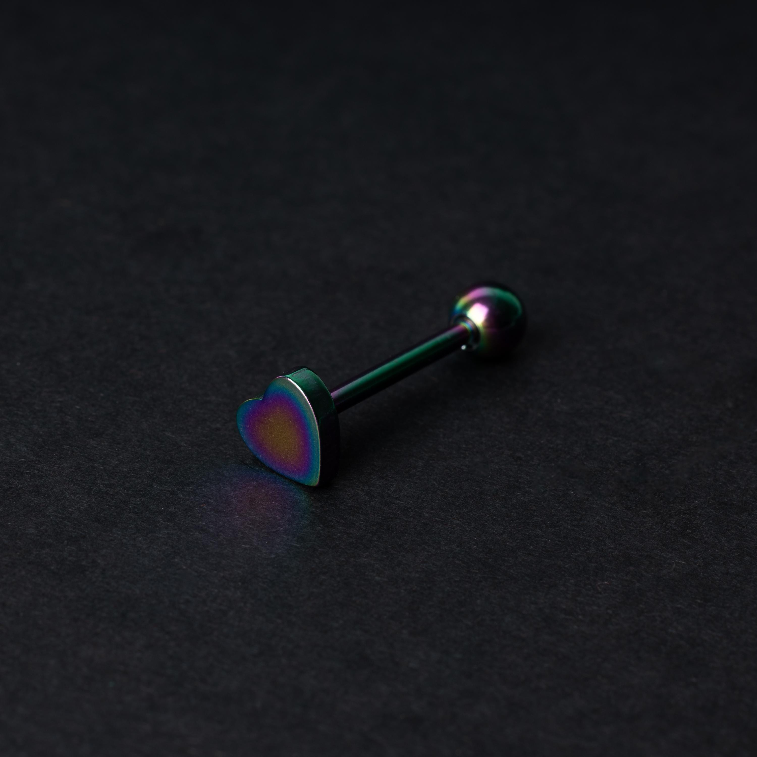 Heart shaped tongue bar in rainbow, displayed on a dark background.