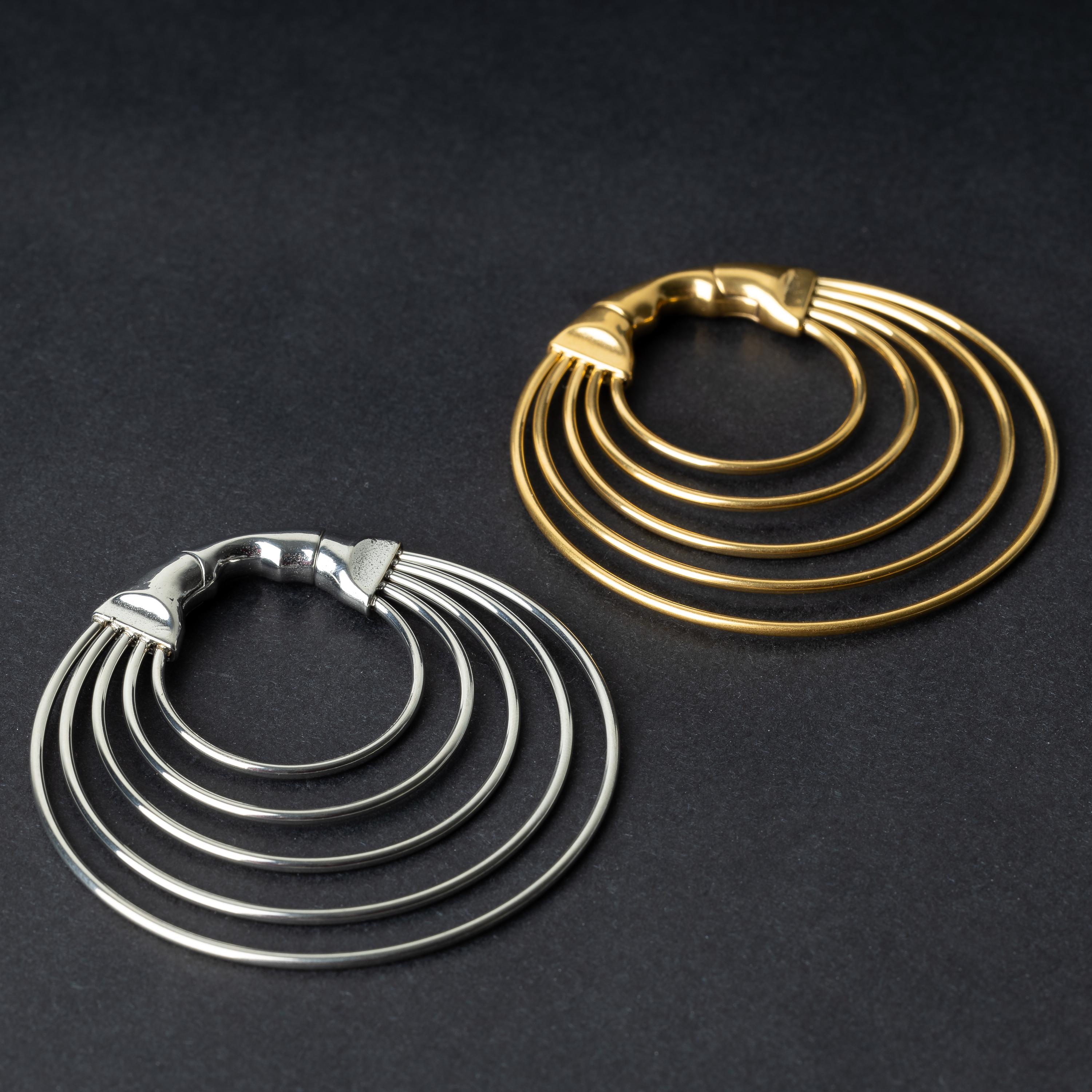 Gold and SIlver multi-hoop ear weights in polished silver, featuring five cascading hoops and a seamless hinge closure, displayed on a dark background.