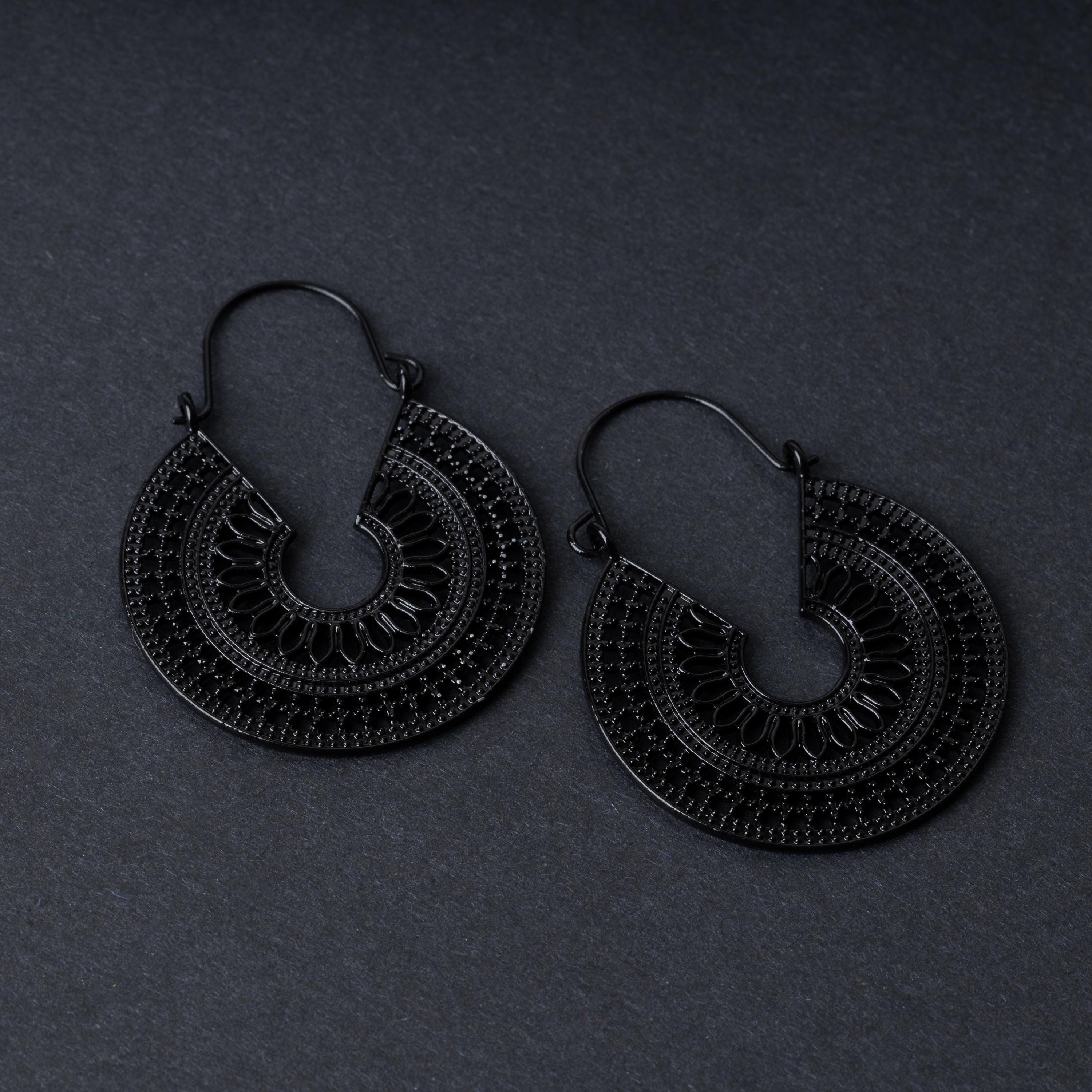 Pair of black hoop earrings with intricate cutout details and textured patterns, displayed on a dark background.