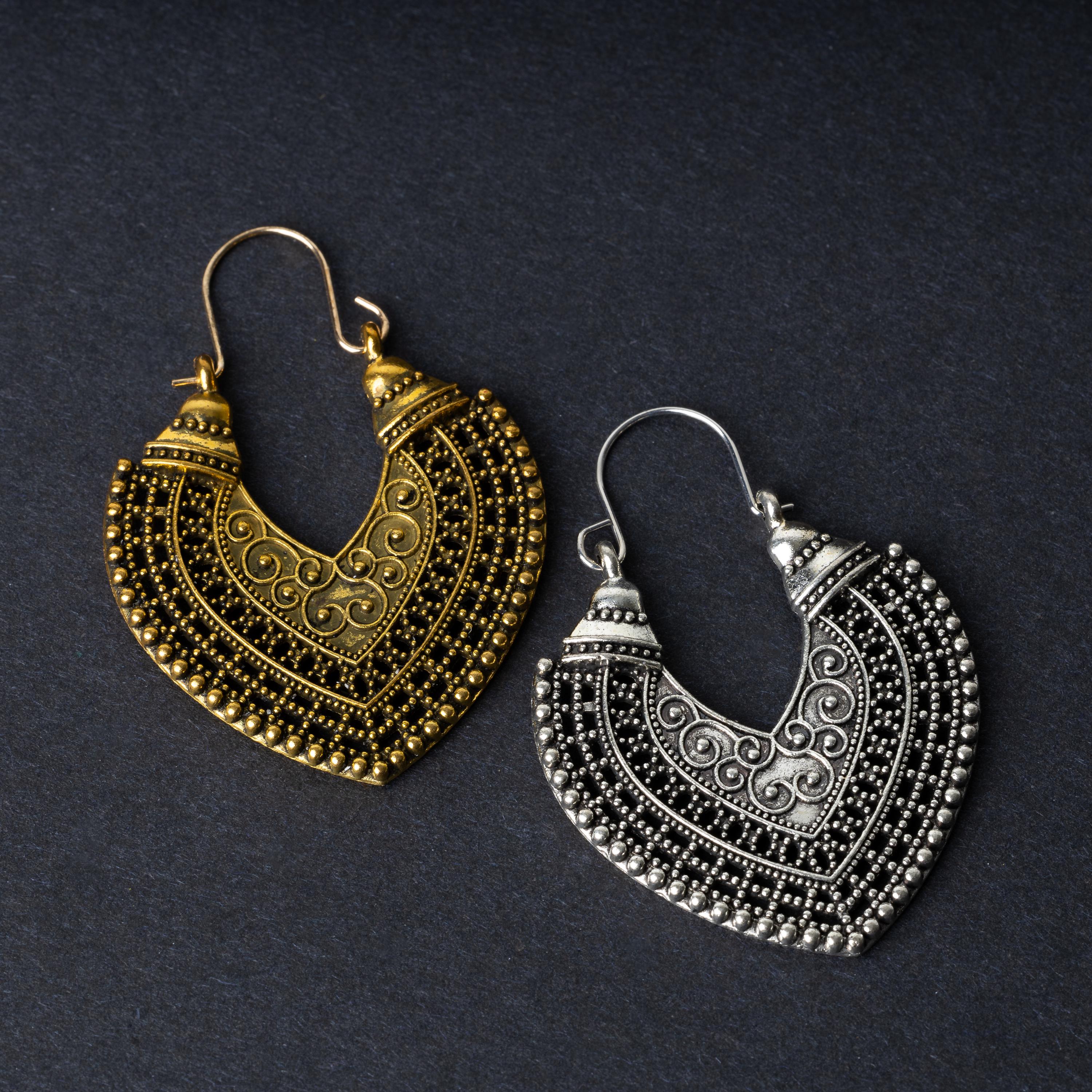Pair of earrings in antique gold and silver finishes with intricate patterns and textured detailing, displayed on a dark background.