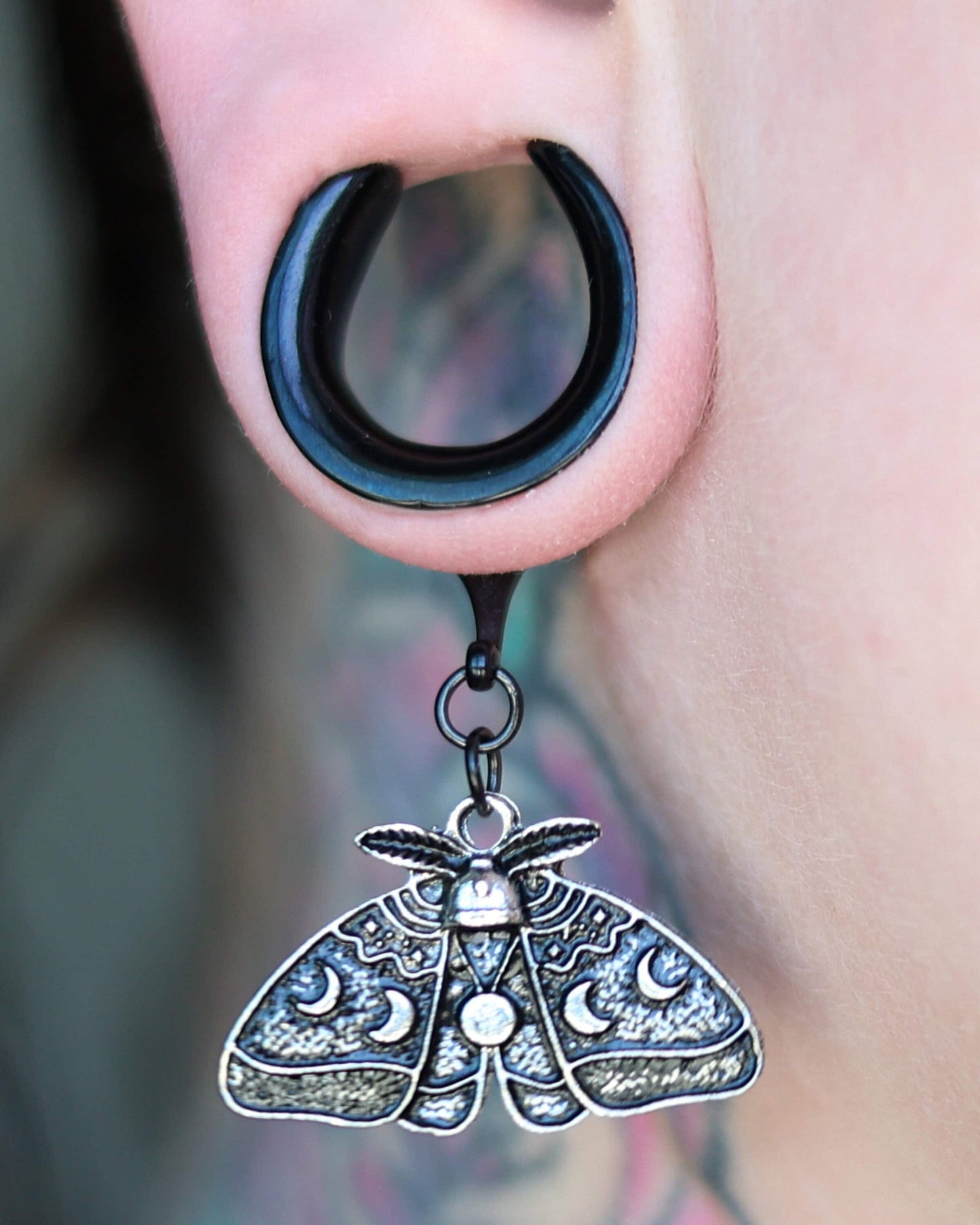 Luna Moth Saddle Hanger displayed on a models ear.