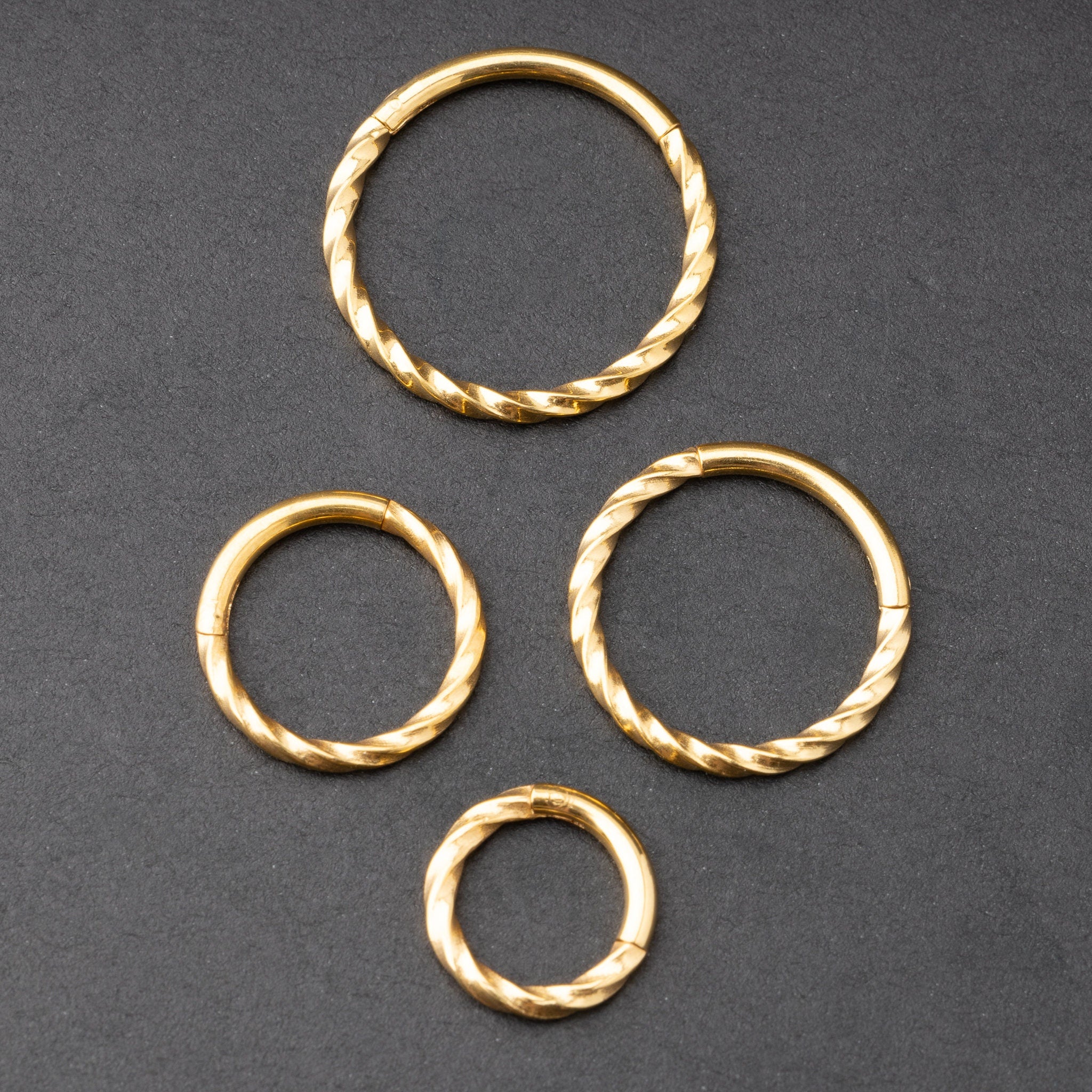Gold seamless rings with a twisted rope texture, shown in four sizes on a dark background.
