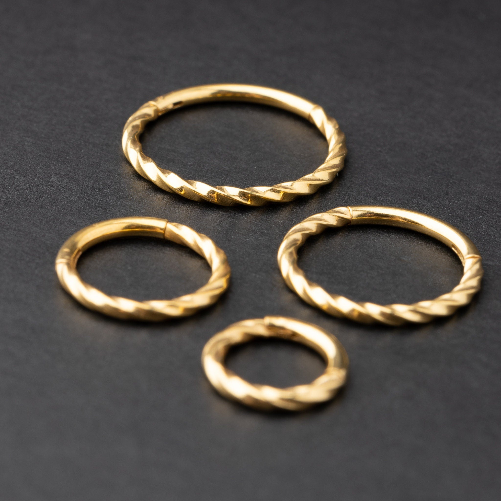 Gold seamless rings with a twisted rope texture, shown in four sizes on a dark background.