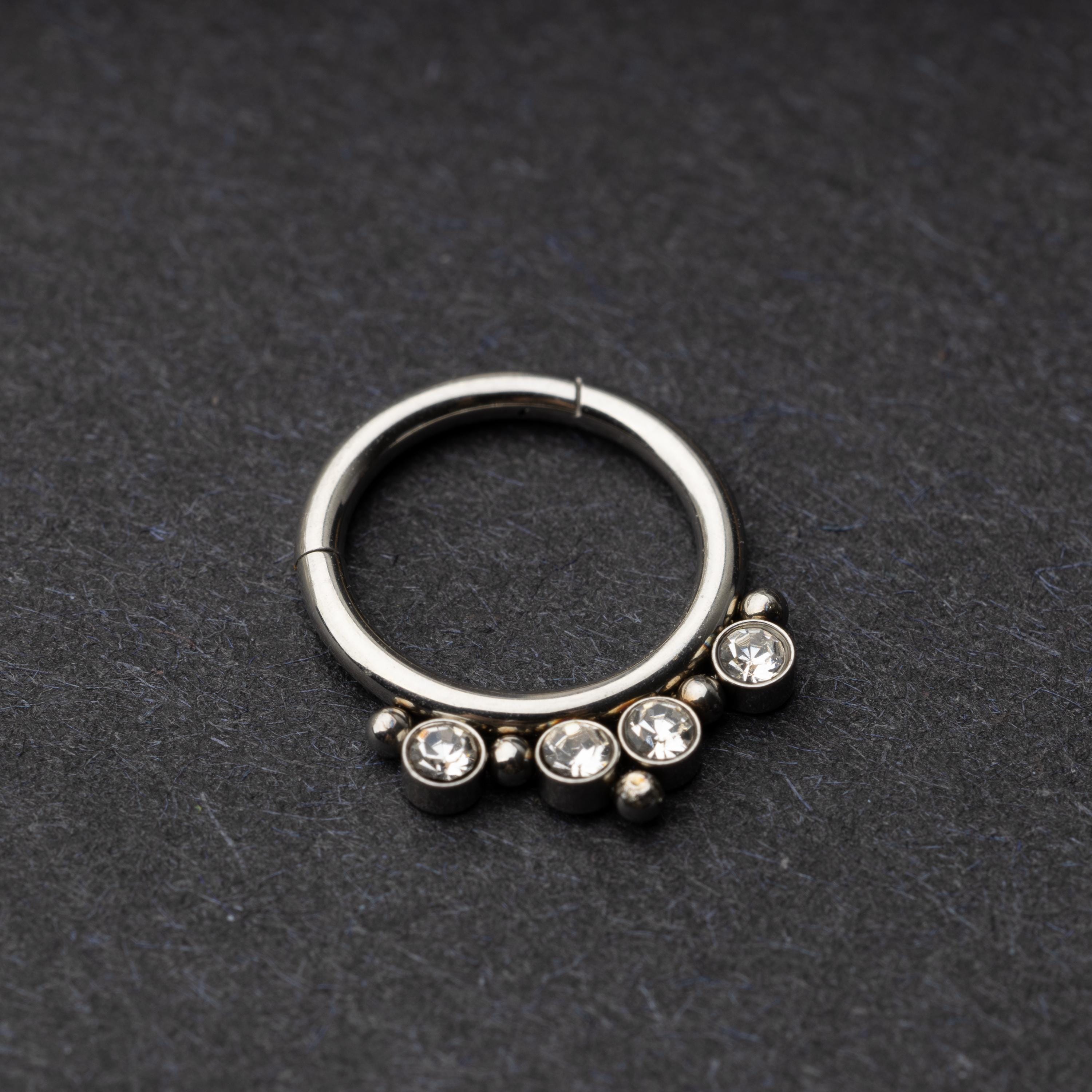 A stainless steel clicker with clear gemstones and bead accents, suitable for septum or daith piercings.