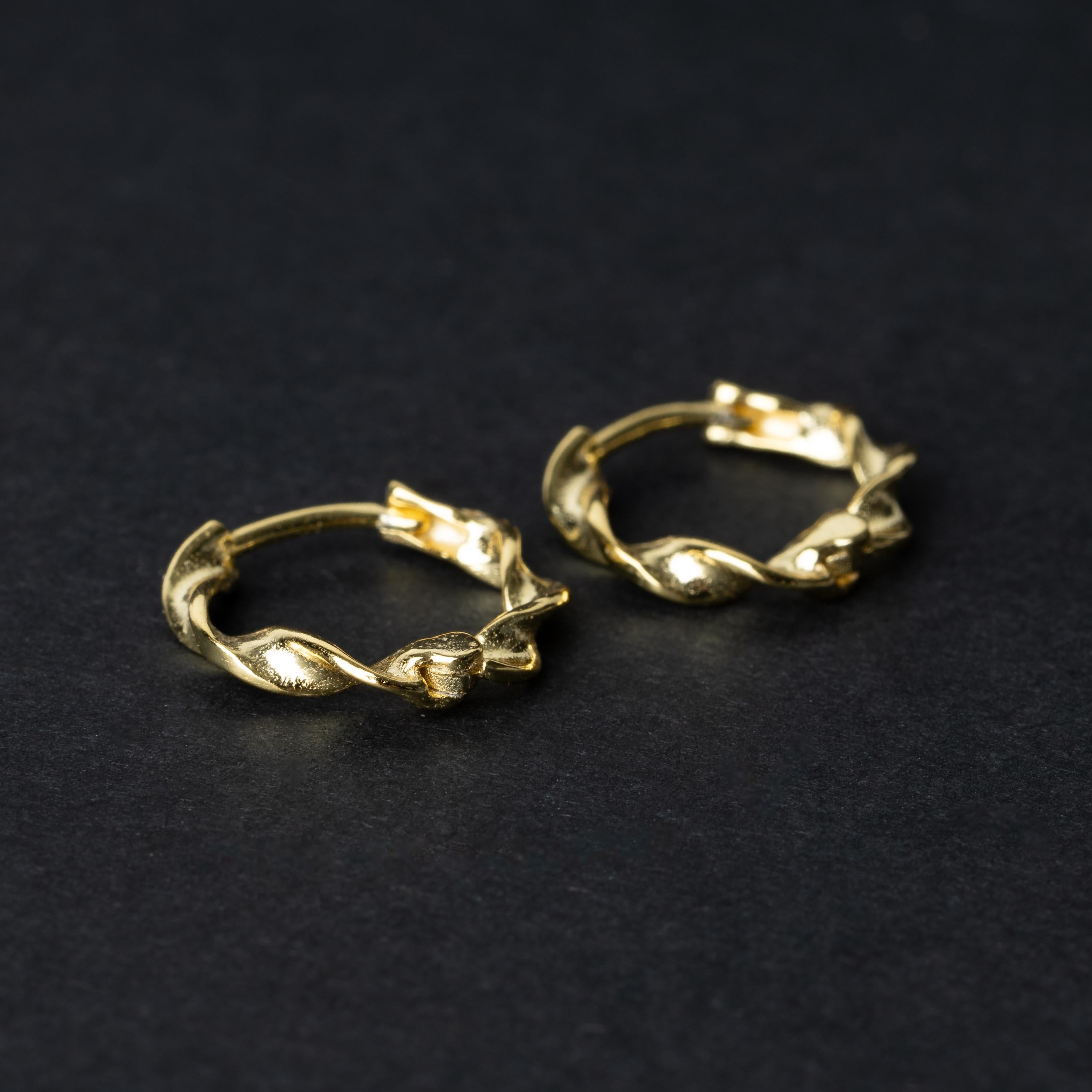 Gold-toned twisted rope design clickers made from 925 sterling silver, displayed on a black background.