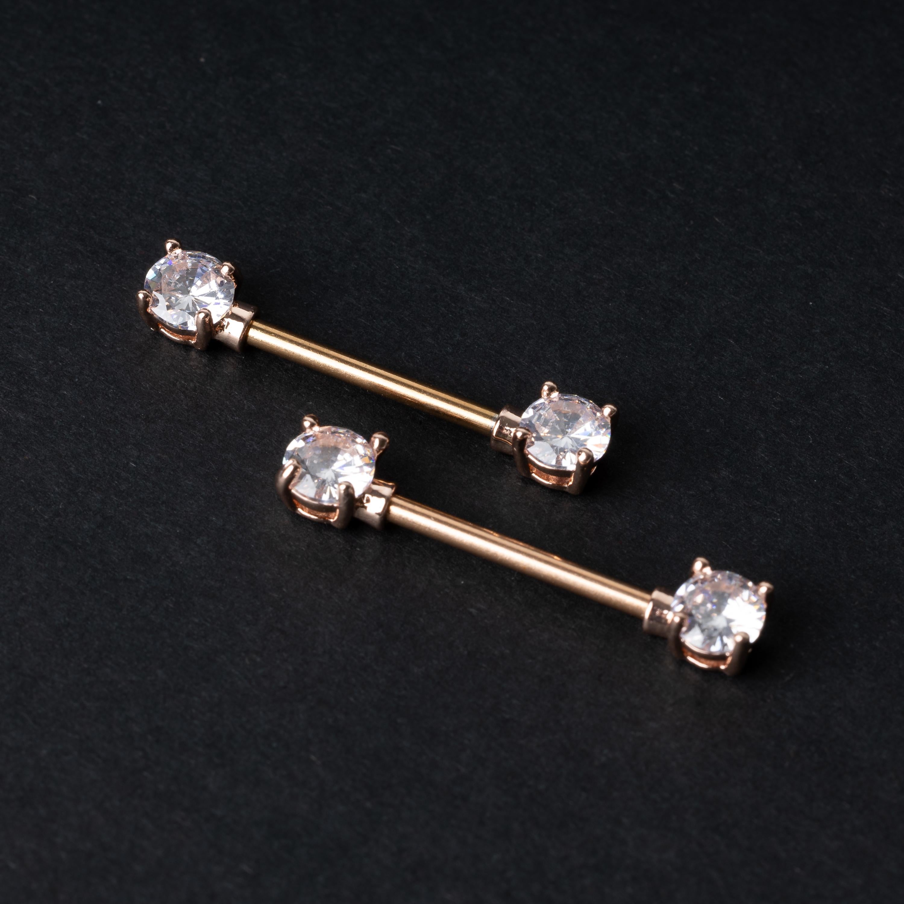 Two Crystal-studded barbells in rose gold displayed on a dark background.