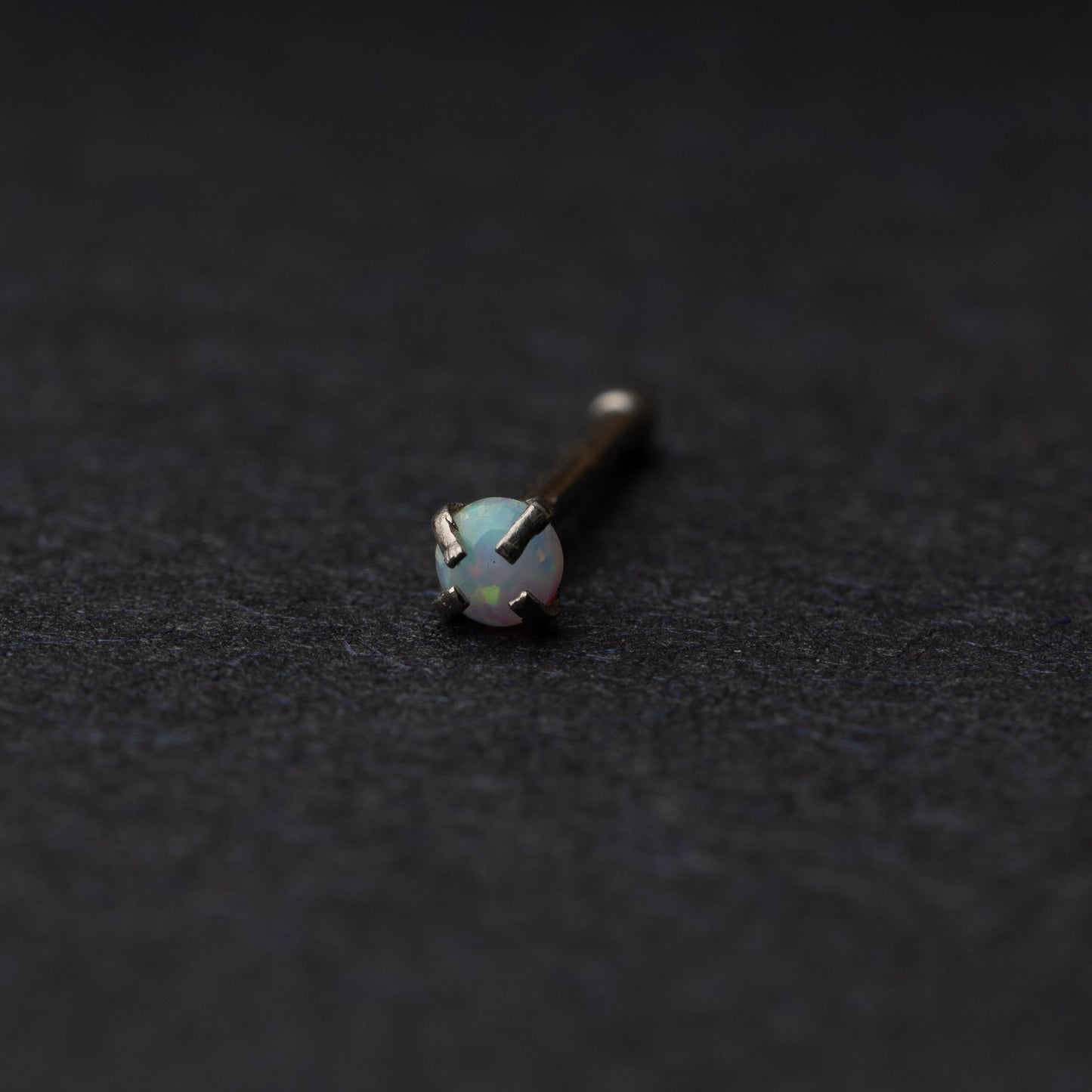 Opal nose stud displayed on a dark background