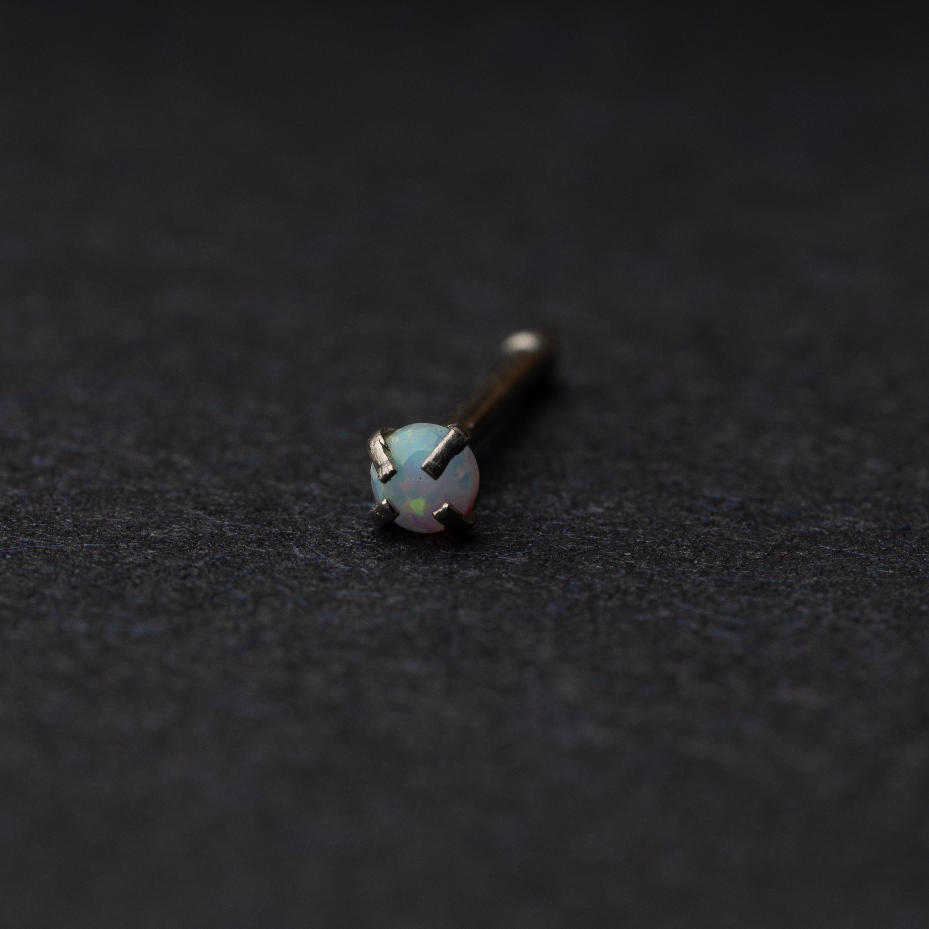 Opal nose stud displayed on a dark background