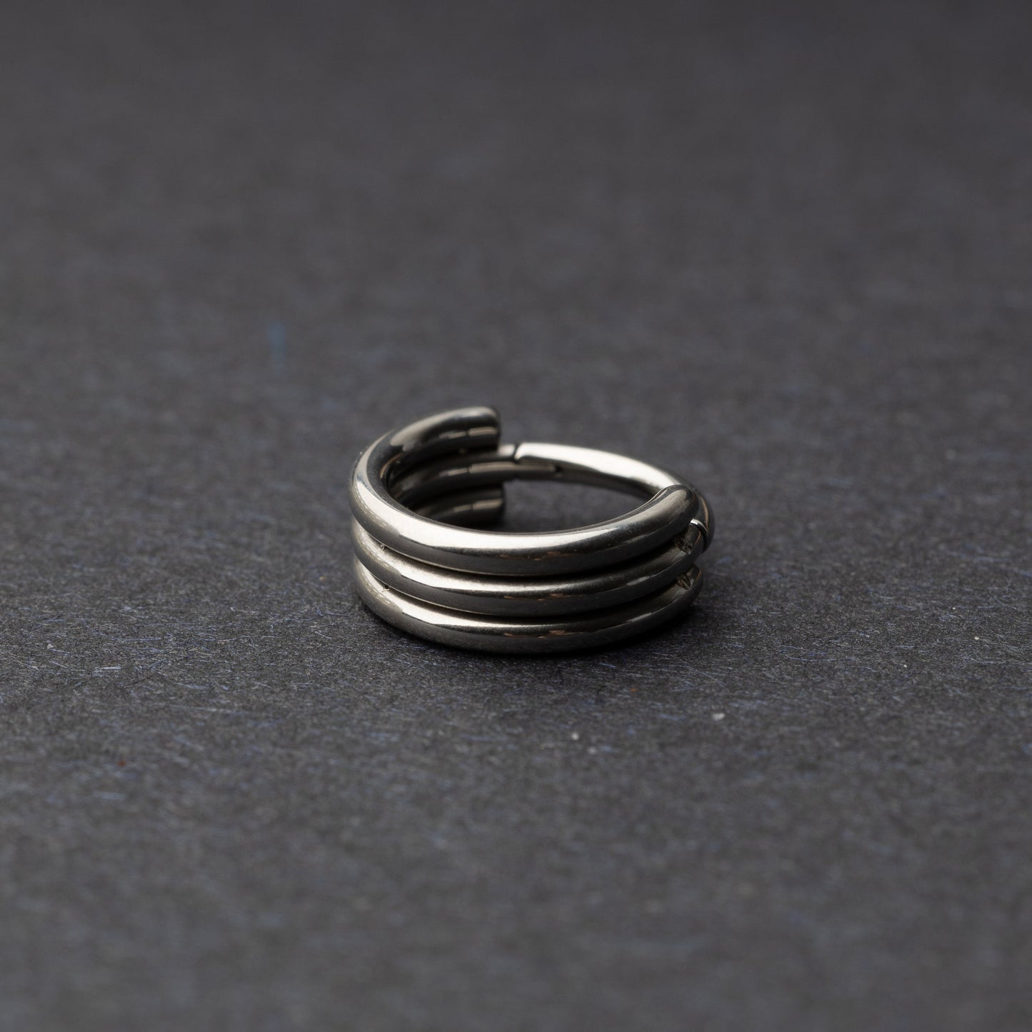 Triple-band seamless hoop rings in a silver finish displayed on a dark background, highlighting their sleek and modern design.