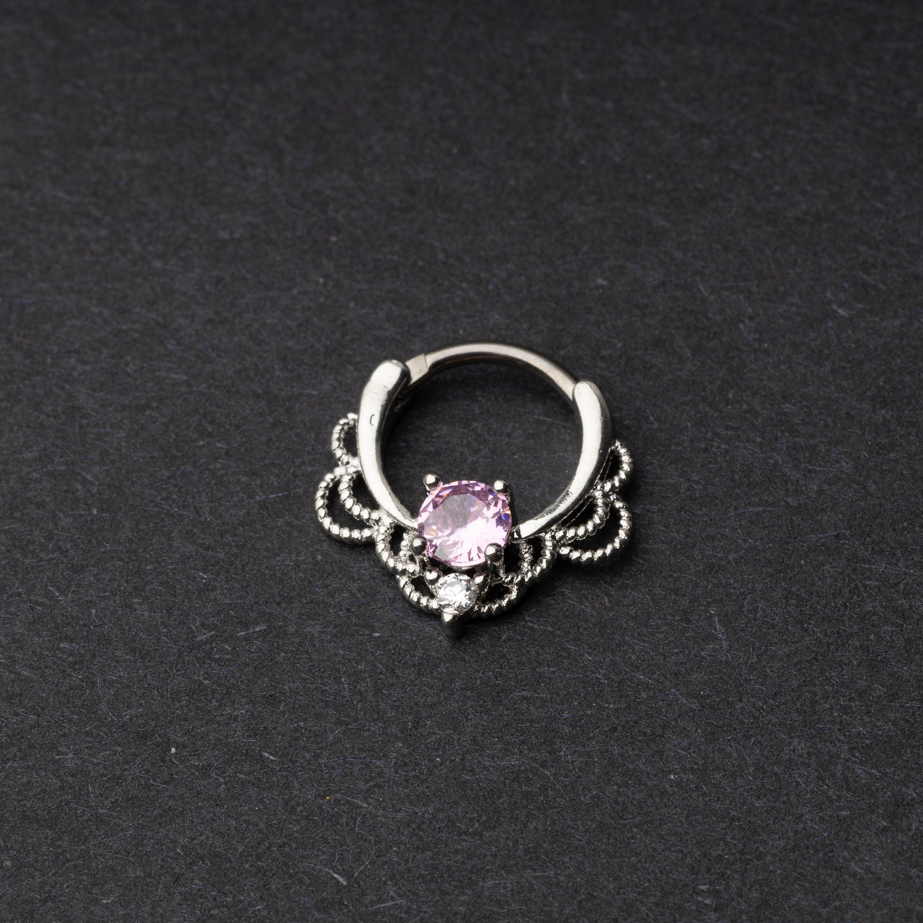 Silver Ornate Septum Ring with a pink gem on a dark background.