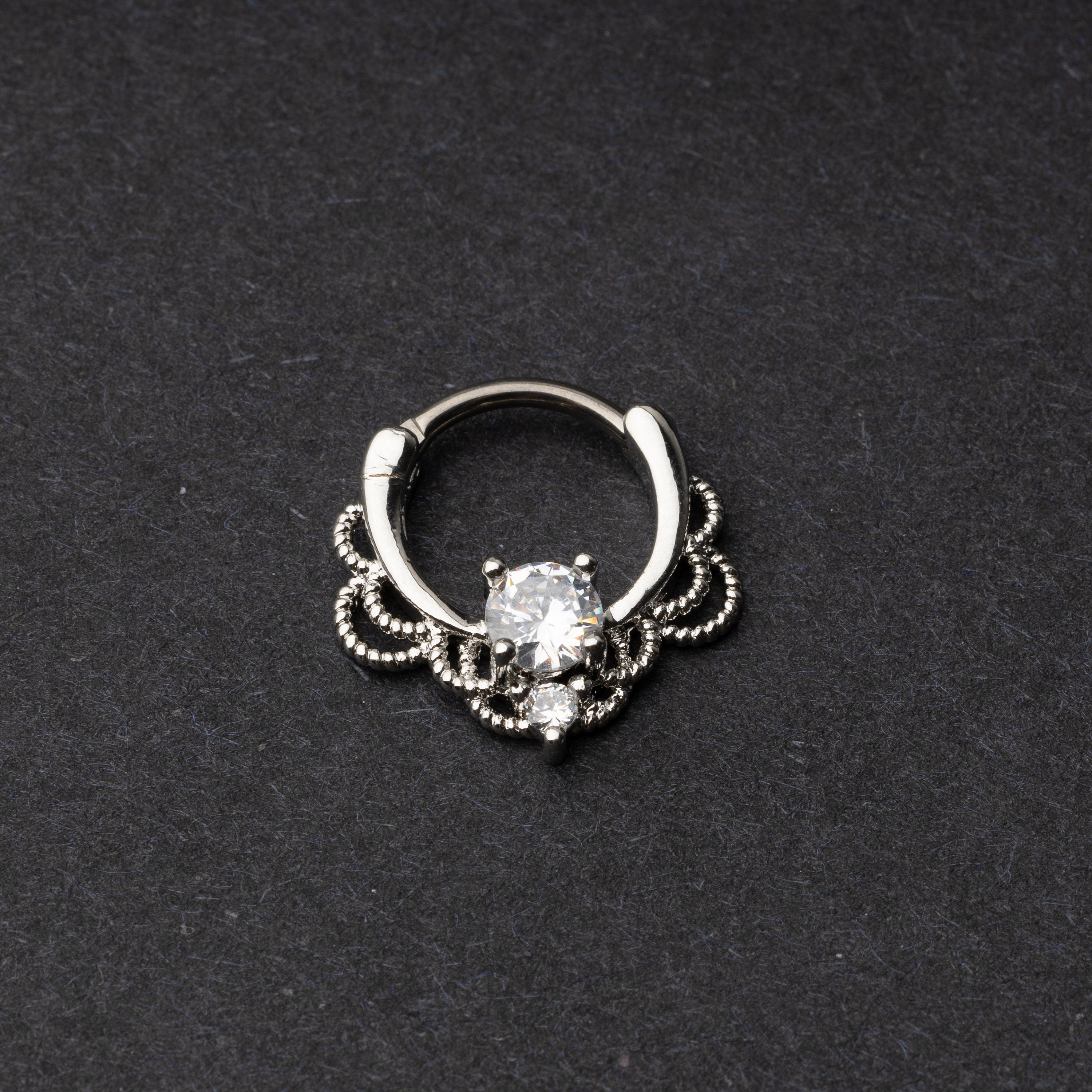 Silver Ornate Septum Ring with a Clear Gem on a dark bacground