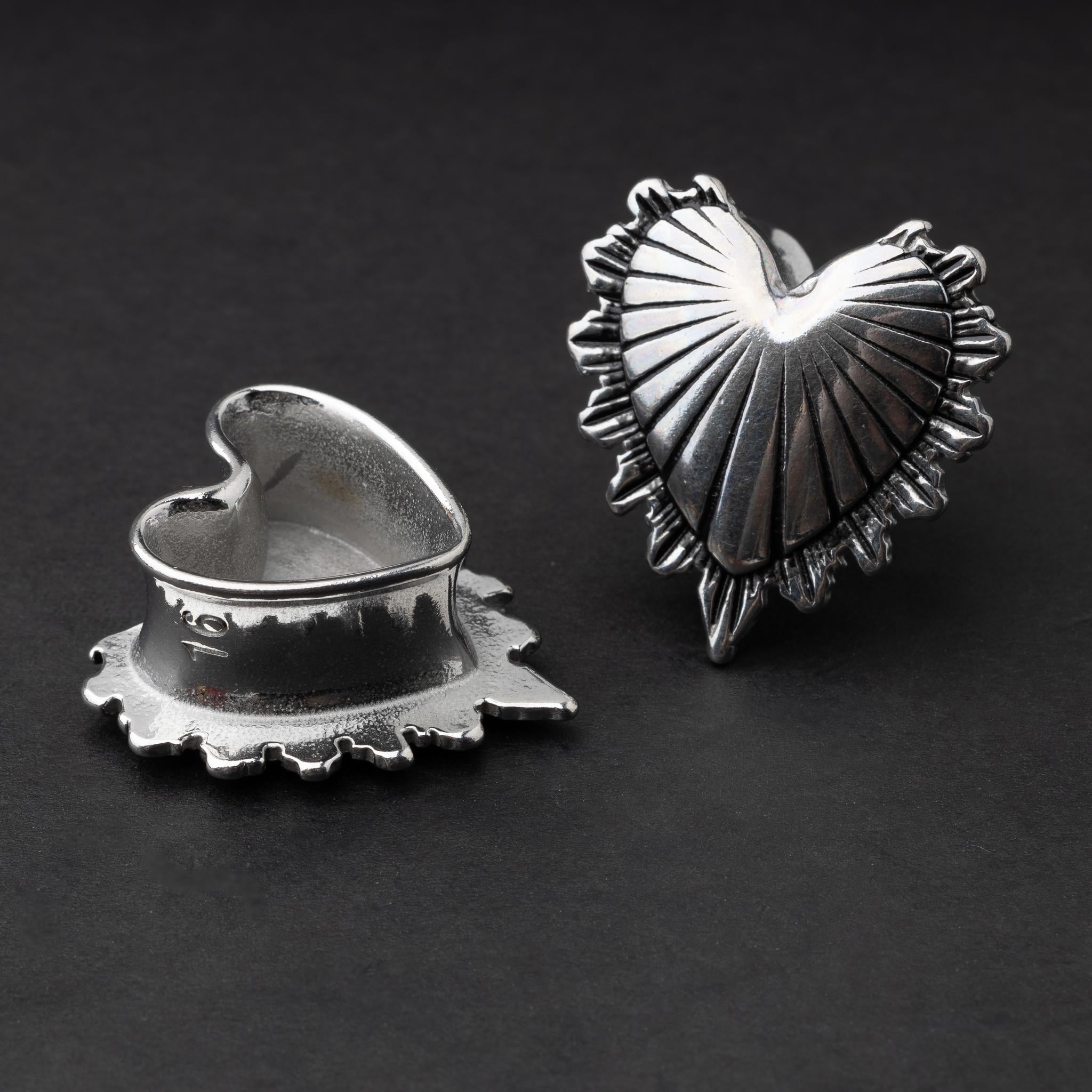 Sacred Heart plugs in gold and silver finishes, showcasing intricate 3D heart designs with a radiant pattern, displayed on a matte dark background.