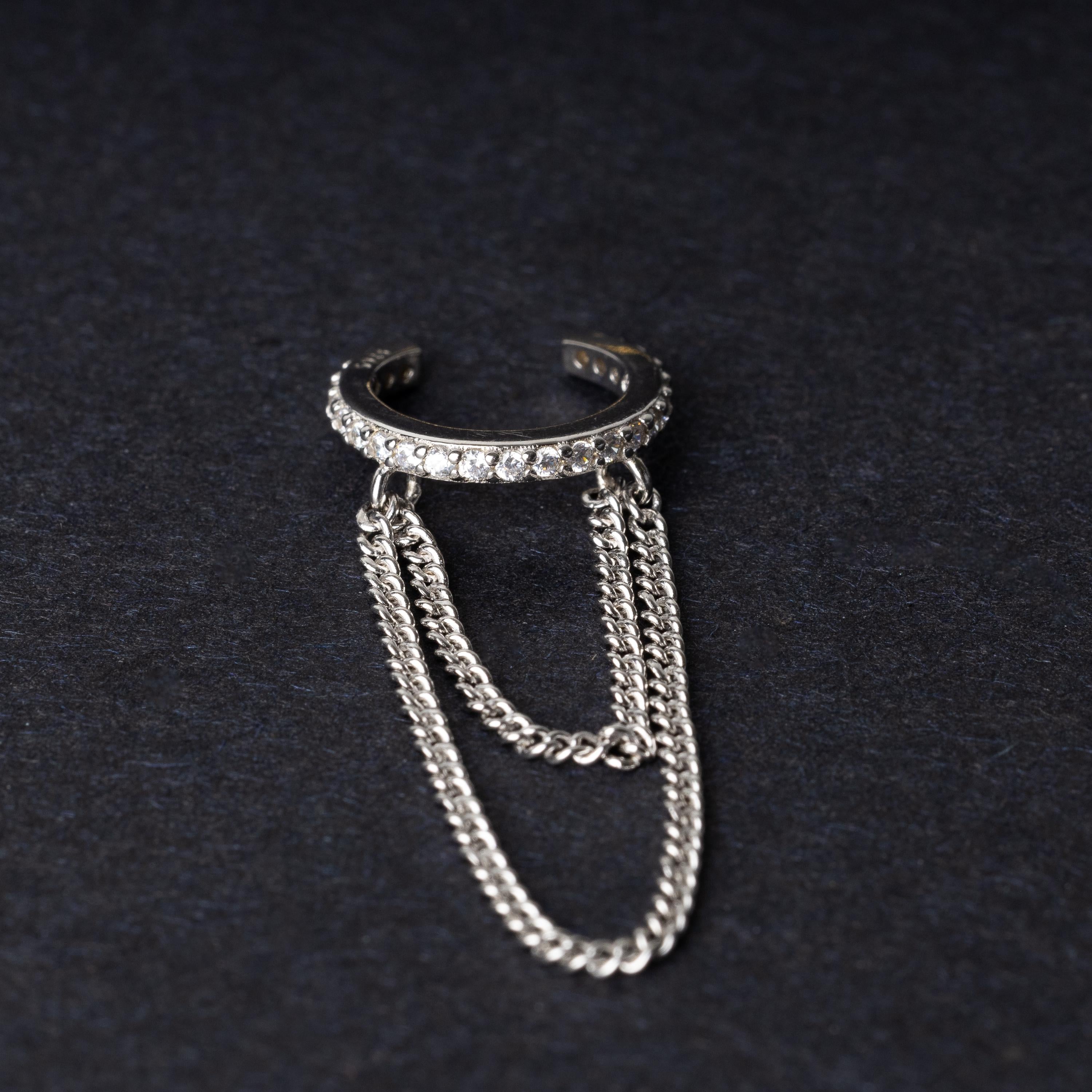 Septum clicker with double chains and gem-encrusted arc, in silver shown on a dark background.