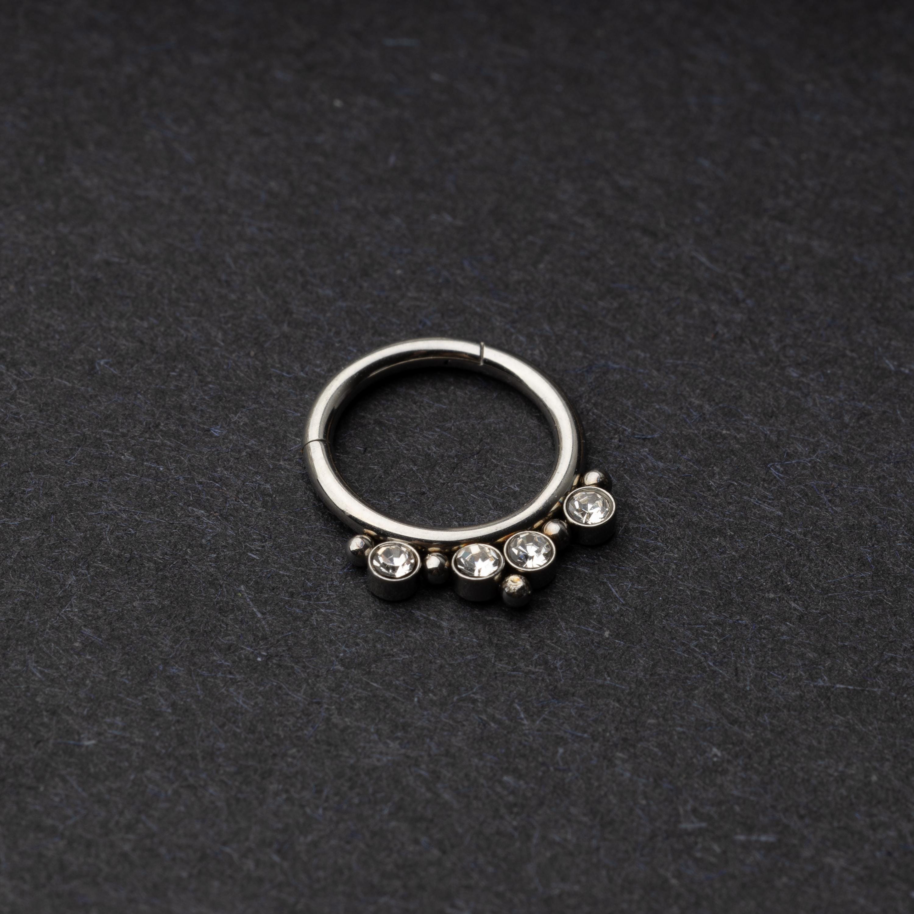 A stainless steel clicker with clear gemstones and bead accents, suitable for septum or daith piercings.
