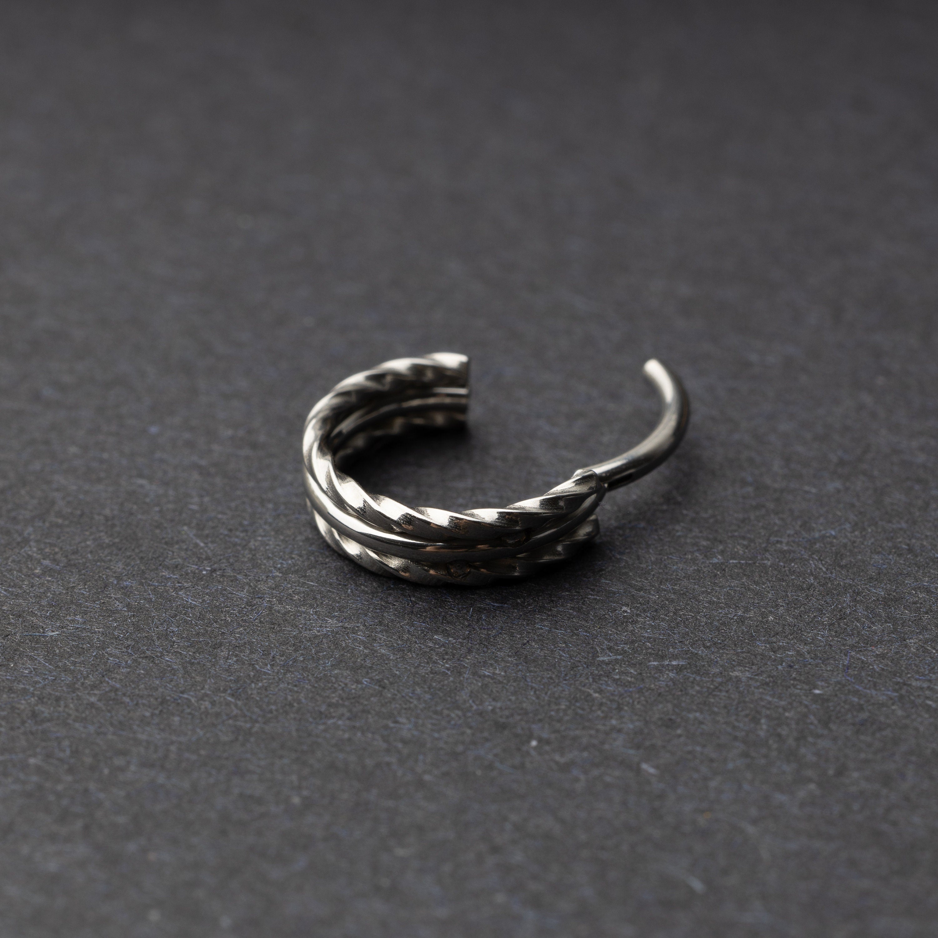 Textured stacked clicker in stainless steel finish with a triple-ring design, displayed on a dark background.