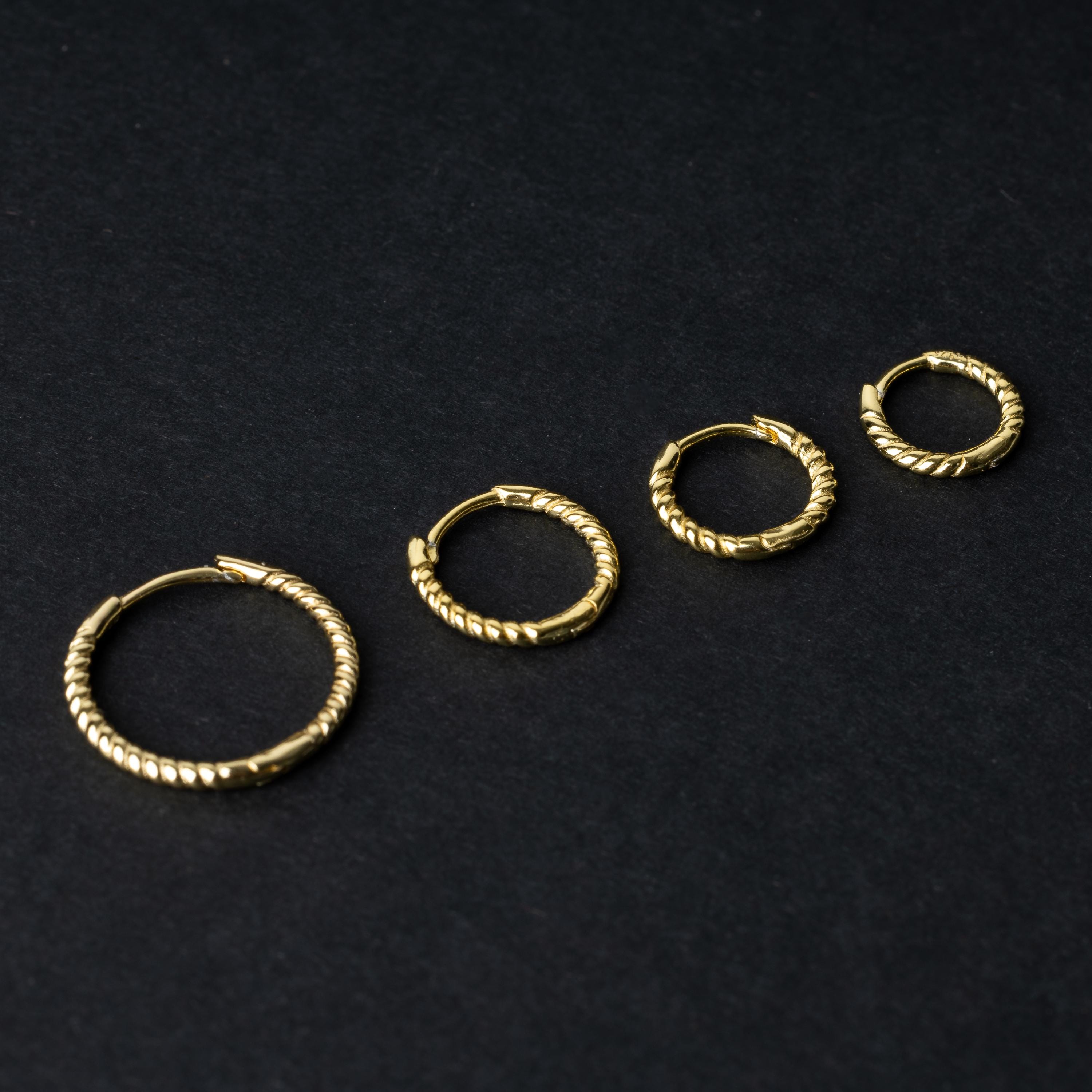 Gold rope-textured clicker rings in four different sizes, displayed on a dark background.