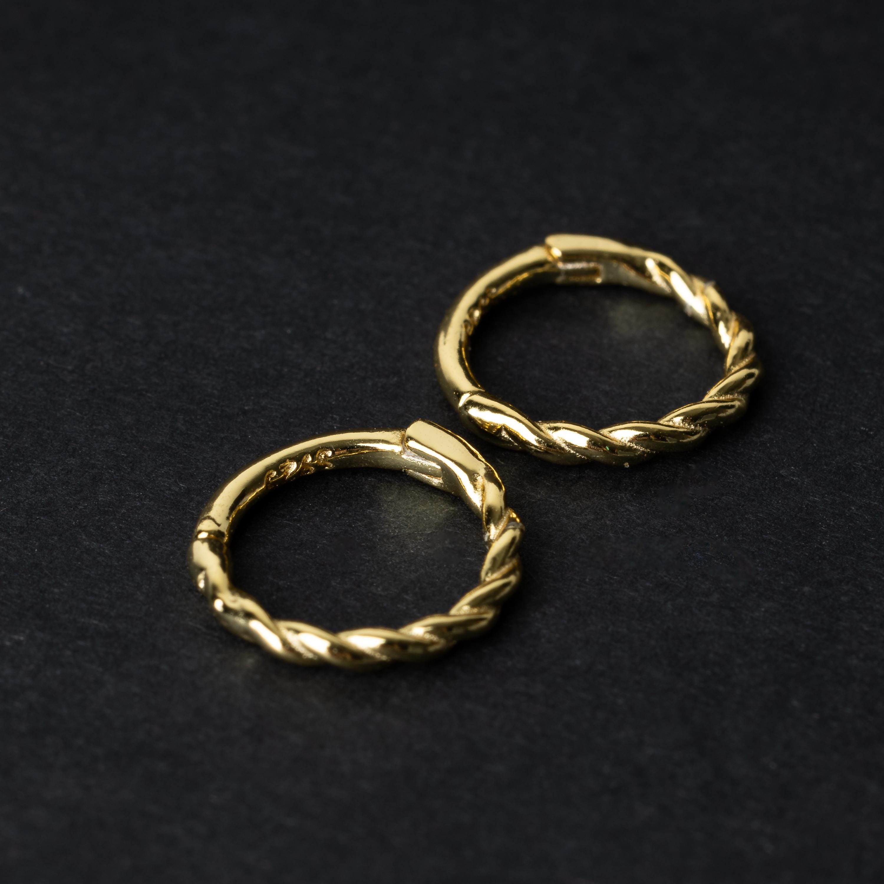 Two gold-plated, braided 925 sterling silver hoops displayed on a dark textured background.