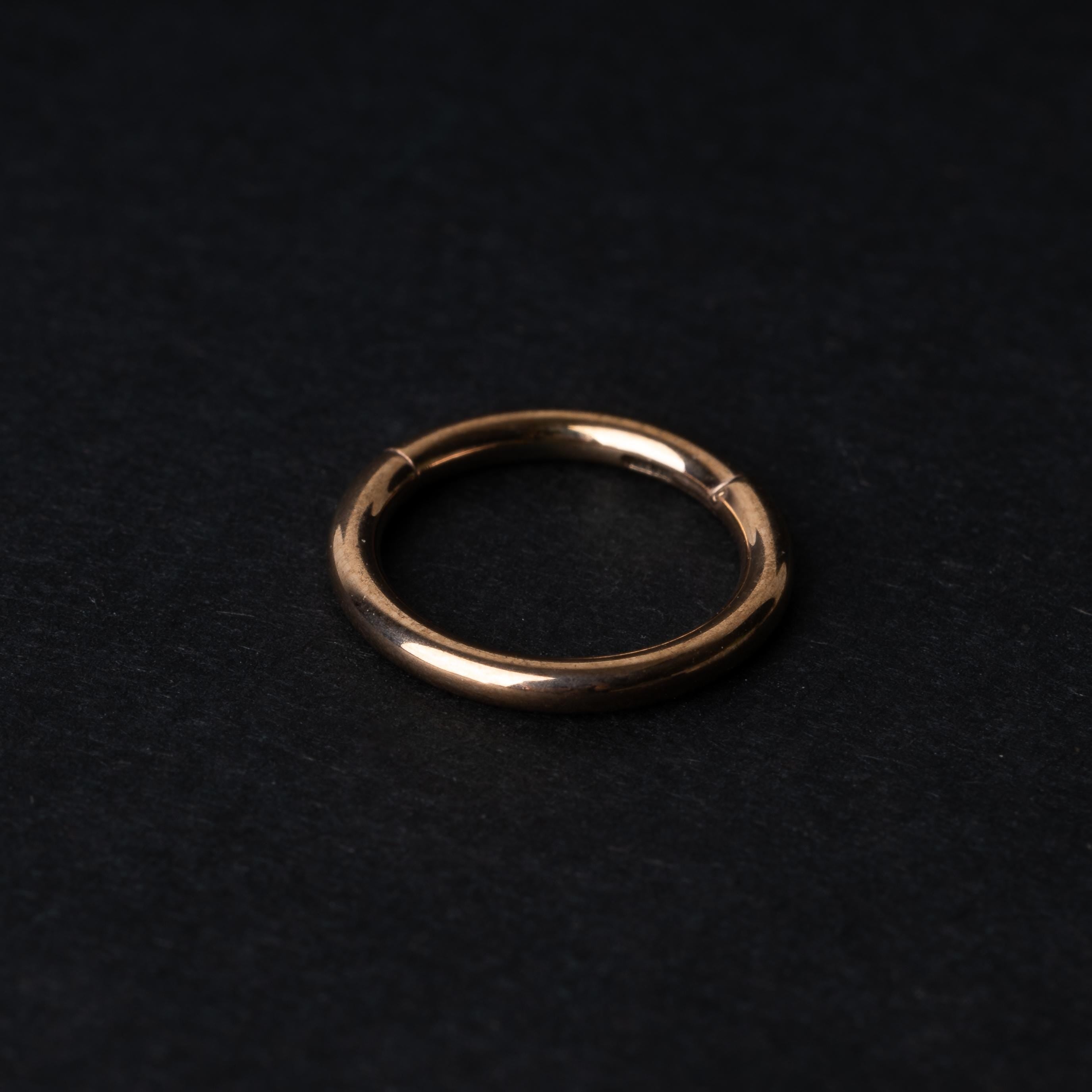 A rose gold Seamless Clicker displayed on a dark background.