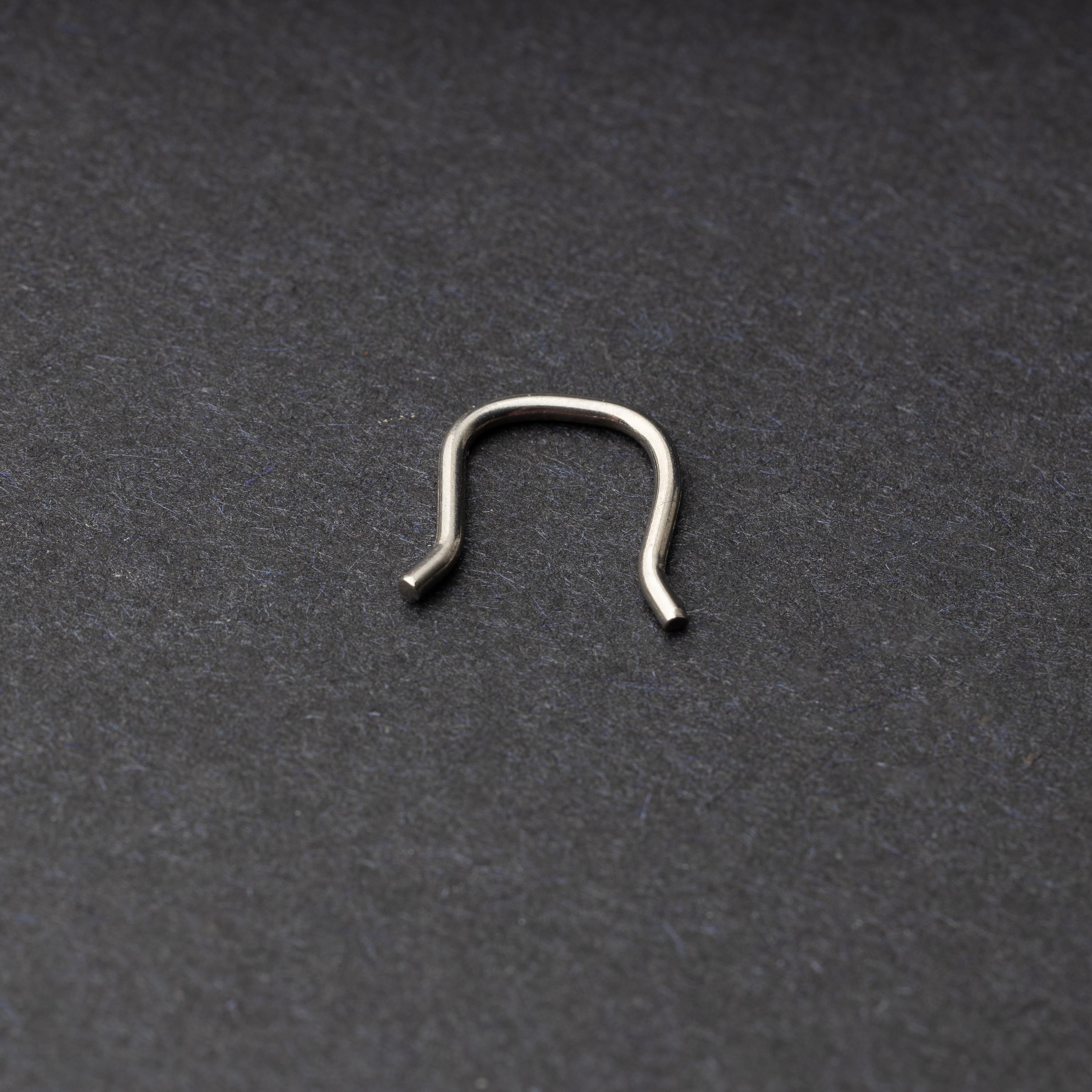 U-shaped septum retainer in silver displayed on a dark background