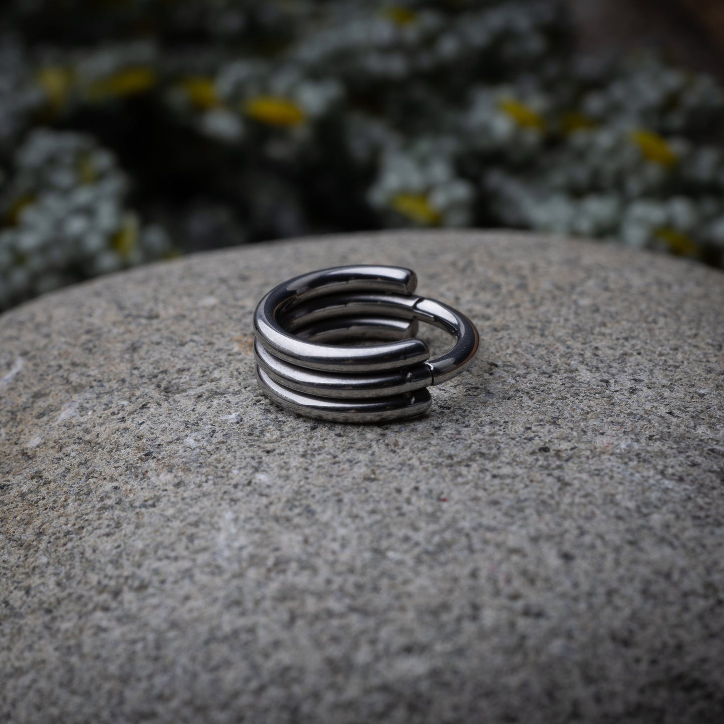 Triple-band seamless hoop rings in a silver finish displayed on a dark stone background, highlighting their sleek and modern design.