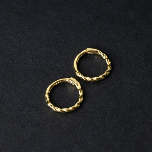 Two gold-plated, braided 925 sterling silver hoops displayed on a dark textured background.