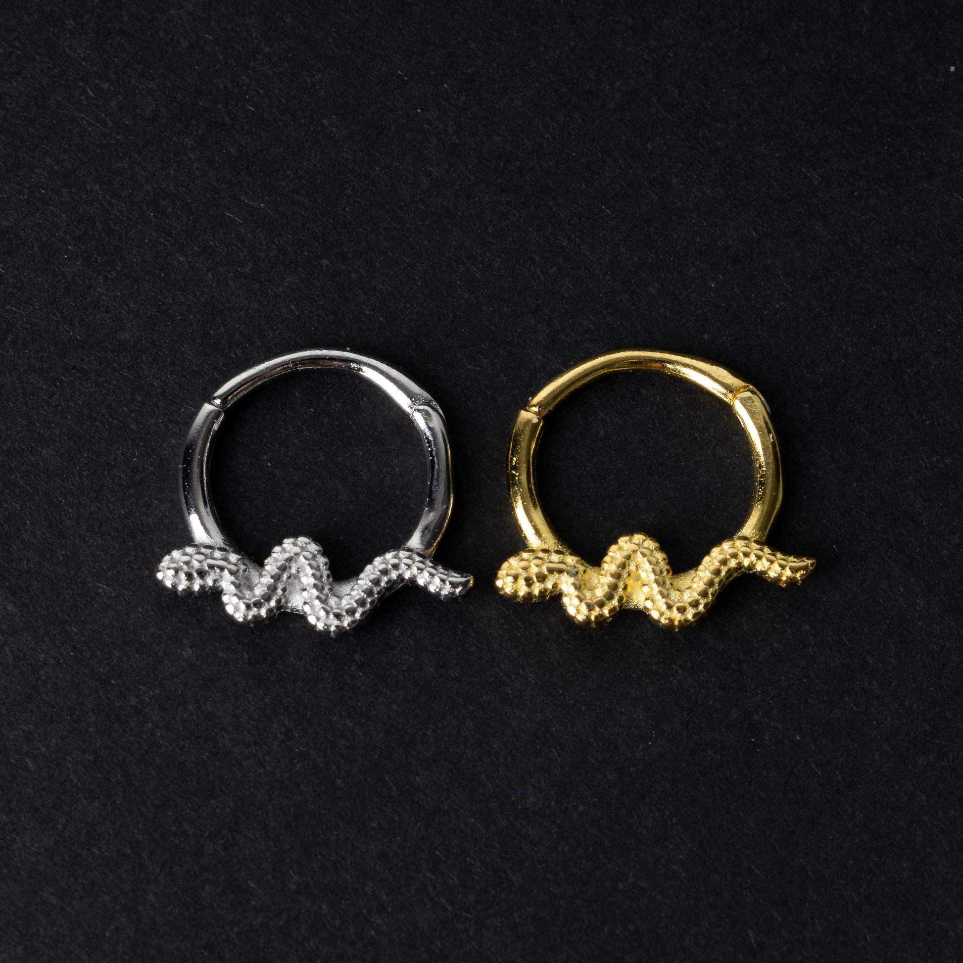 Silver and gold snake motif hinged rings crafted from 925 Sterling Silver on a dark background.