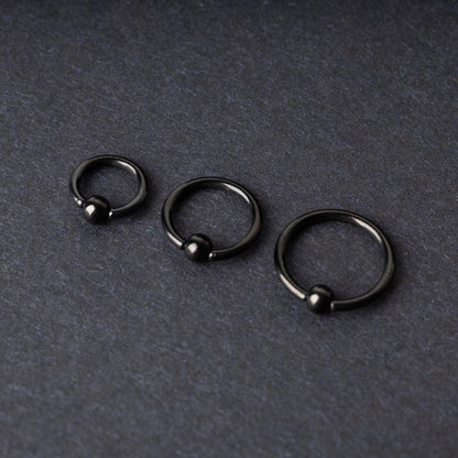 Three black ball closure rings (BCR) in varying sizes, displayed on a dark background with a polished finish and secure captive balls.