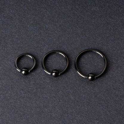 Three black ball closure rings (BCR) in varying sizes, displayed on a dark background with a polished finish and secure captive balls.
