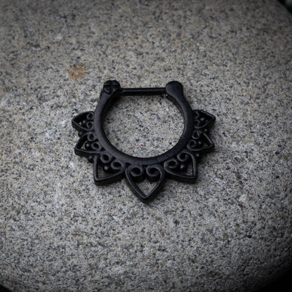 Black septum clicker with intricate geometric and swirl detailing.