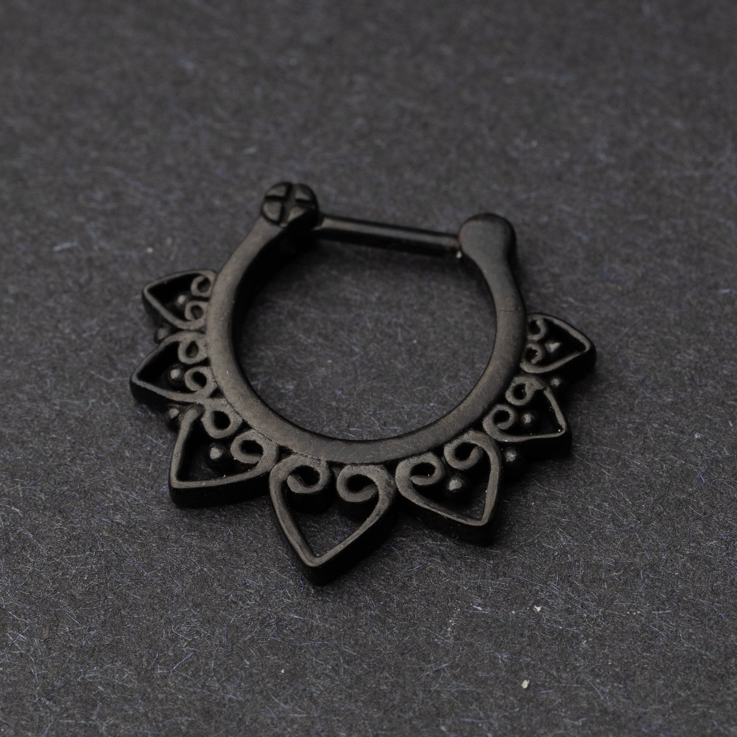 Black Ornate Septum Clicker on a dark background