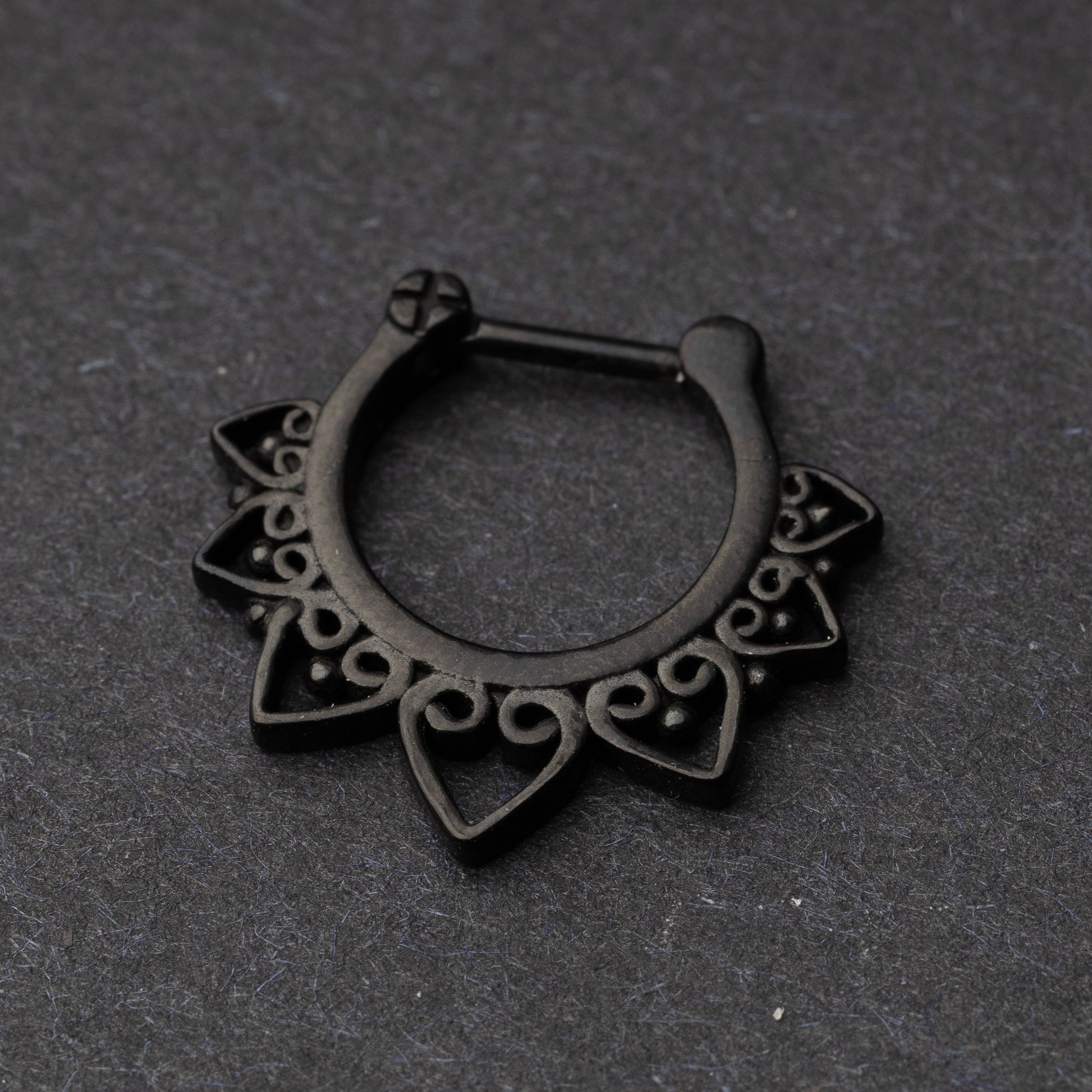 Black Ornate Septum Clicker on a dark background