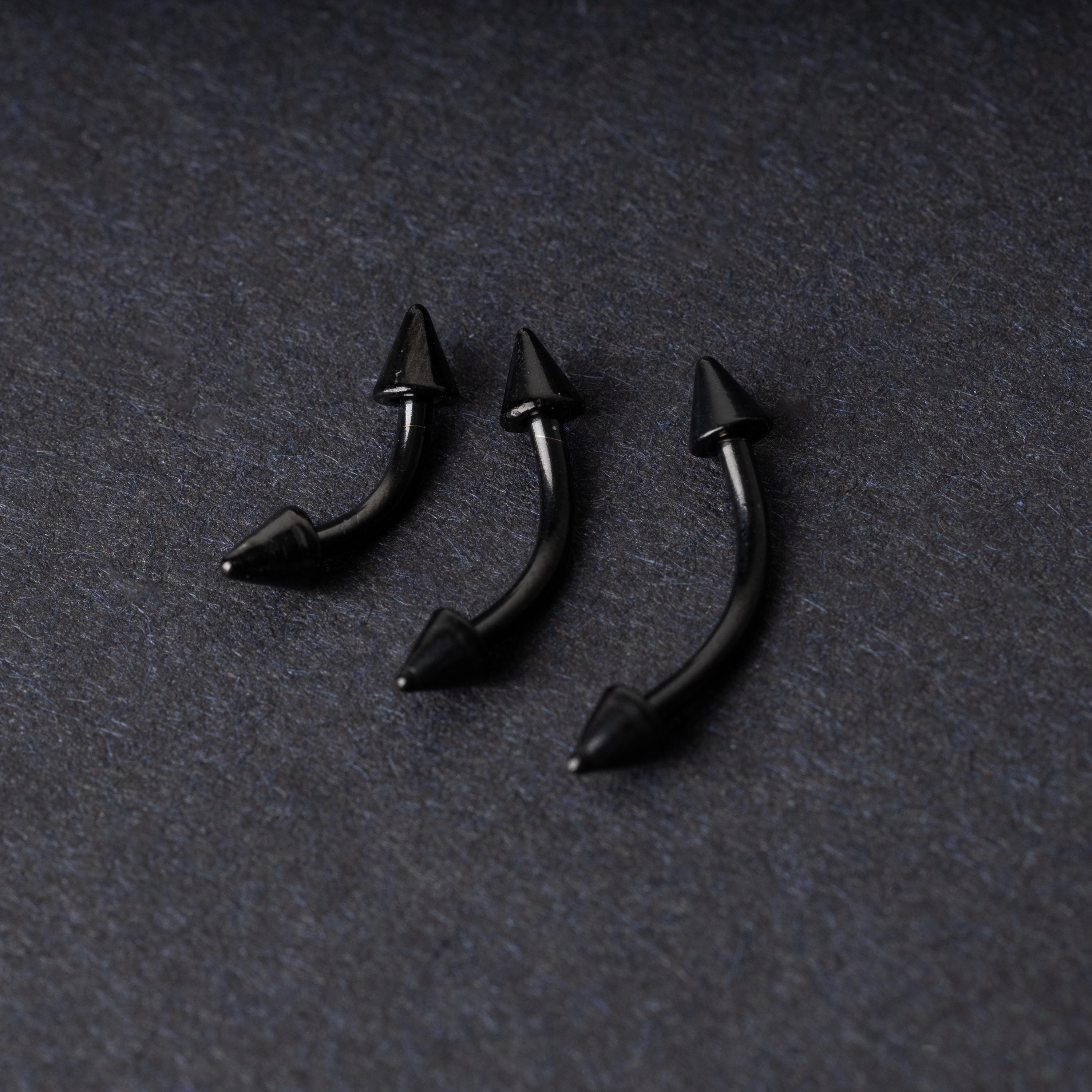 Three black curved barbells with spiked ends, displayed on a dark background with a polished finish.