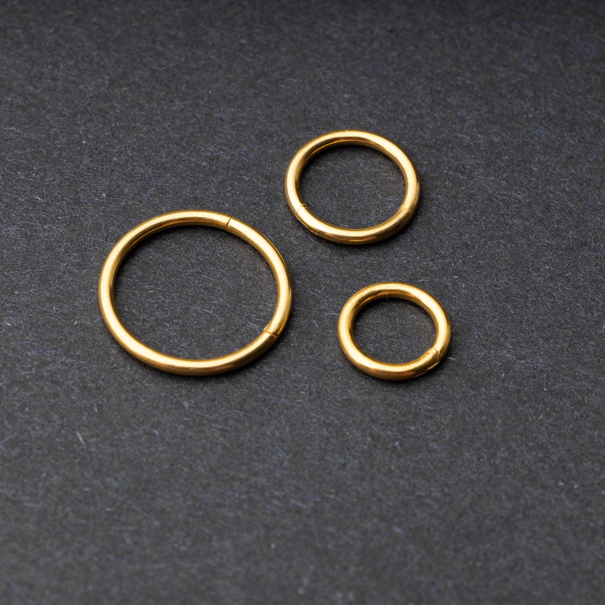 Seamless Clicker hoop in gold, showcasing four different sizes displayed on a dark background