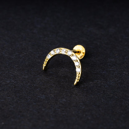 Gold crescent moon stud earring featuring CZ gems, displayed on a dark background.
