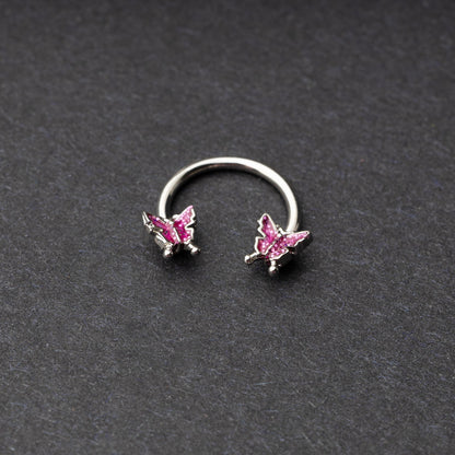 Horseshoe hoop featuring a butterfly charm, displayed on a dark background.