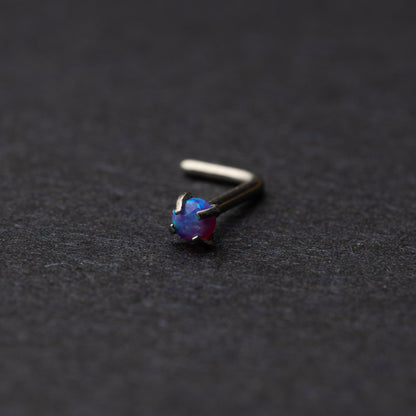 Opal L shaped nose stud on a dark background
