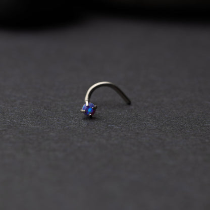 Single opalescent nose screw with a prong setting, displayed on a dark background.