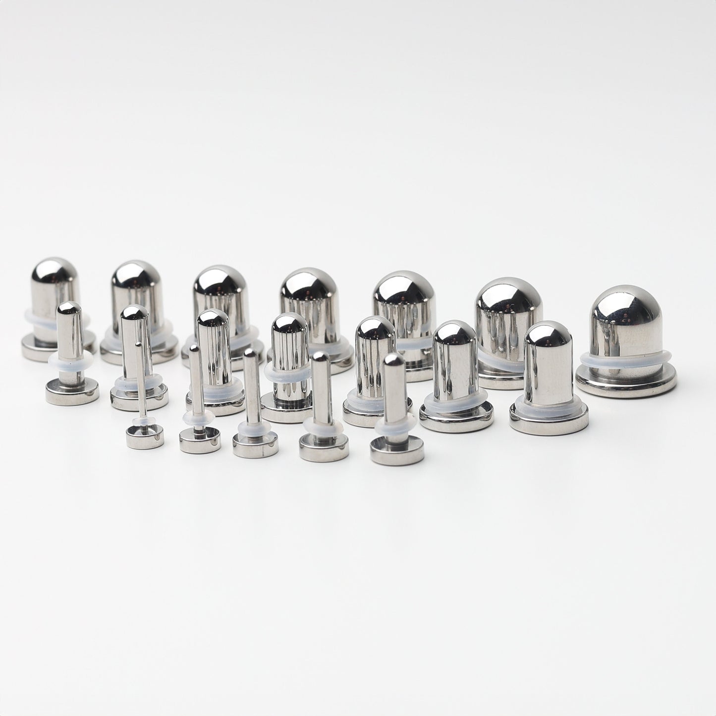 A complete dead stretching kit with polished stainless steel plugs and tunnels in multiple sizes, displayed on a white background.