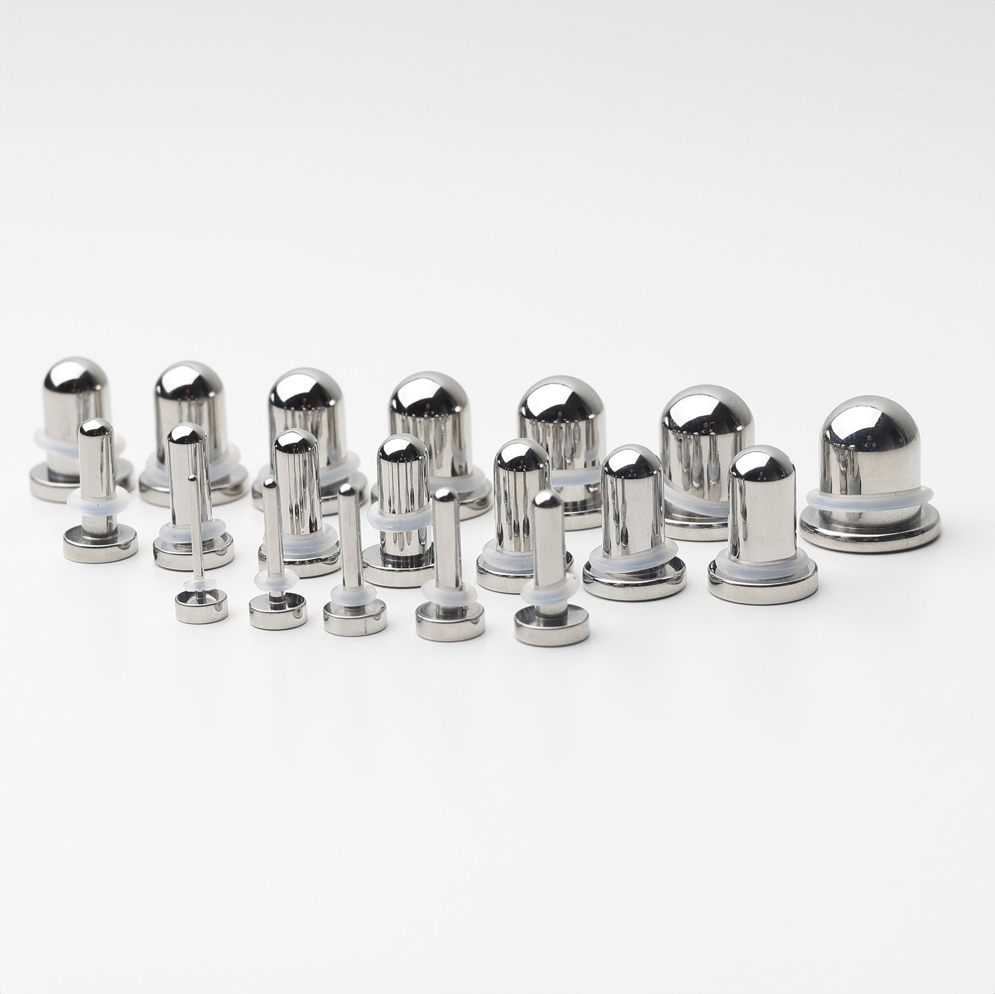 A complete dead stretching kit with polished stainless steel plugs and tunnels in multiple sizes, displayed on a white background.